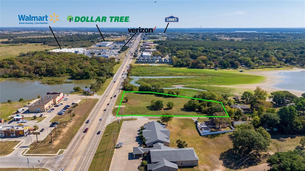 This 1.7-acre commercial corner lot on Main Street in Gun Barrel City offers high-visibility frontage, strong daily traffic exposure, and close proximity to Cedar Creek Lake, located approximately 0.2 miles away. Positioned at the intersection of Main Street and Spruce Trail, the property provides multiple access points and a level, development-ready layout within city limits. Located along one of the area’s primary commercial corridors with an estimated 15,000 vehicles per day, the site benefits from consistent traffic flow and surrounding national retail presence. Walmart is located approximately 0.5 miles from the property, with Lowe’s, restaurants, and service-based businesses within 1 mile, creating an established commercial environment that supports a range of business uses. The property is served by city water, city sewer, and available electricity, allowing for streamlined development planning. Its open configuration and corner positioning support visibility from multiple directions, which is valuable for retail, office, hospitality, or mixed-use concepts, subject to local zoning and approvals. Cedar Creek Lake is a major regional destination for recreation and tourism, drawing consistent visitor traffic throughout the year. The property’s proximity to the lake, along with its location near residential neighborhoods and commercial centers, supports both local and visitor-driven demand. Gun Barrel City is located approximately 55 to 60 miles southeast of Dallas, providing direct access to the DFW Metroplex while continuing to see growth tied to lake activity and regional expansion.
This property offers a combination of location, exposure, and utility access that is increasingly limited along Main Street. Contact the listing agent for additional information or to evaluate development potential.