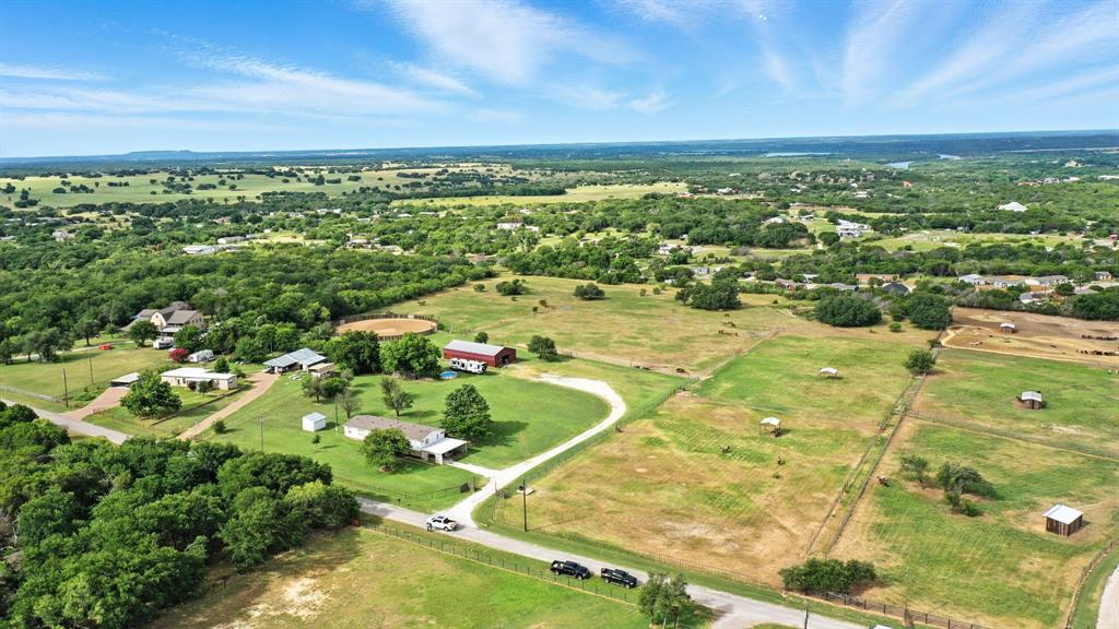 16.647 acre horse property next to Silverado on the Brazos. Discover an exceptional equestrian property just outside the gates of Silverado on the Brazos without the HOA, deed restrictions, or easements. This 16.647 acre horse setup is thoughtfully designed for managing broodmares and foals and is ready for you to build your dream home with panoramic views of the Brazos River Valley and the surrounding ranchland. The property includes a 40 by 70 show barn with 10 stalls measuring 12 by 12, each with front and back windows for maximum airflow, along with a hot water wash rack, tack room, and 220 amp RV plug. There is a 140 foot round pen and the property is cross fenced into 7 pastures, all in Coastal Bermuda, with slick wire and horse friendly mesh fencing in excellent condition. Each pasture is equipped with freeze proof water spigots. Additional features include a quarter acre stock pond and two water wells supplying water for livestock and domestic use. The home is a 2000 model double wide manufactured home offering 2,128 square feet with 4 bedrooms and 2 baths, along with a covered 2 vehicle carport, and is set among mature live oaks providing shade and natural beauty. The land features sandy loam soil ideal for horses and hay production with gently rolling topography and views of the Brazos River and Silverado. The property is located on a cul de sac for added privacy. No deed restrictions, no HOA, and no known easements. This is a rare opportunity to own a turnkey horse property with neighboring ranches, strong infrastructure, and the flexibility to make it your own in Parker County horse country.