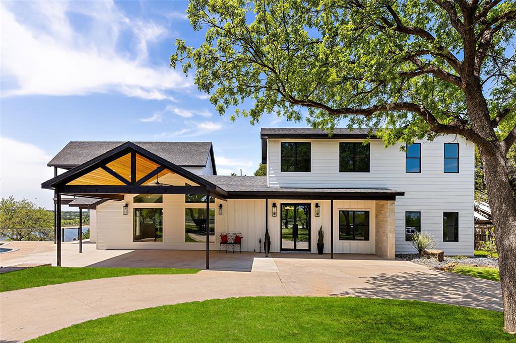 Exquisite design with Family gatherings in mind! Gated entry to This Modern, completely remodeled Lakefront estate offering clean crisp finishes with Walls of Windows, handsome stone fireplace, modern railings, marble countertops and many designer touches. With ample space for 2 families, this home boasts Main level open concept kitchen dining and 2 living areas. The left wing offers 2 guest rooms, an upper primary suite with lakeside balcony. The right wing provides a lower level primary suite with access to cozy and private lakeview patio, 2 upper guest areas and 3rd living or den with gaming area and balcony. You will enjoy the many outdoor spaces surrounded by lush landscape including a beautiful swimming pool with hot tub, and covered, well equipped kitchen. Two level deep water boat dock for your lake toys. Circle drive, detached 2 car garage. Perfectly situated on the Gaines Bend Cliff Line offering unparalleled views of Hells Gate and Possum Kingdoms crystal blue waters.