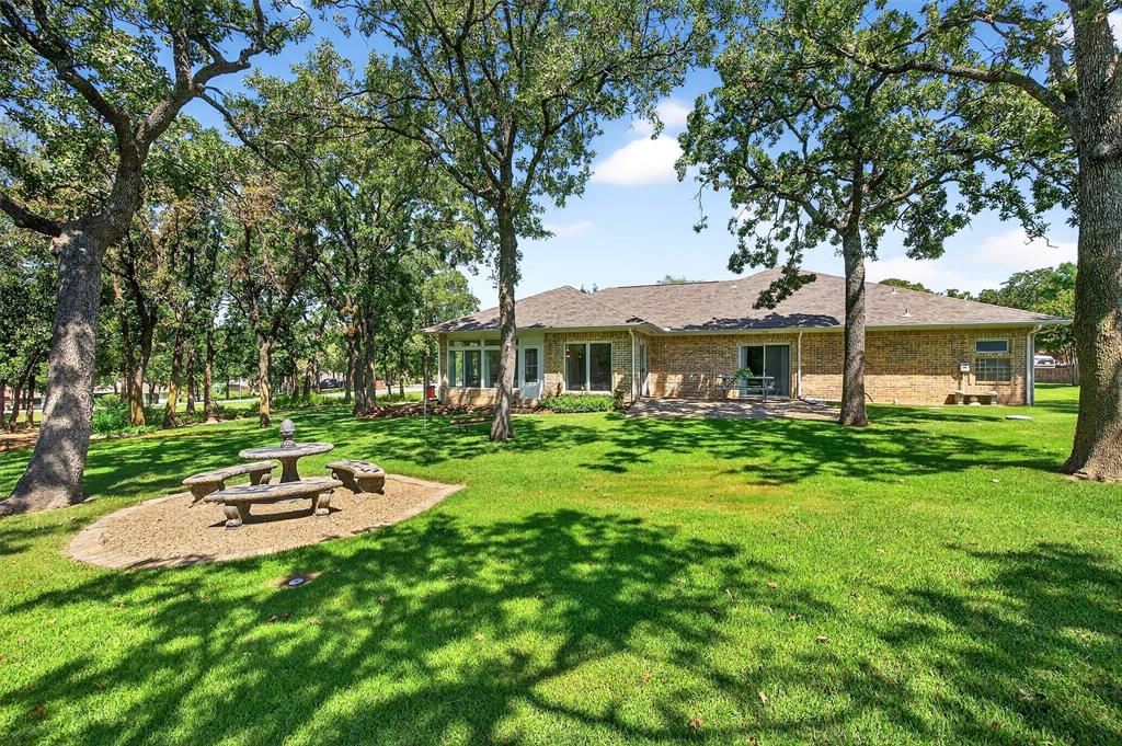 Nestled on over an acre of beautifully treed, meticulously manicured landscape, this stunning home offers peace, privacy, and plenty of space to live and entertain. Situated on a rare double corner lot, the property provides a serene, park-like setting with lush greenery and expansive outdoor living areas perfect for gatherings, play, or simply relaxing in nature. Step inside to a spacious and inviting interior featuring a large living and dining room ideal for entertaining. The quaint kitchen is a chef’s delight with double ovens, stainless steel appliances, granite countertops, and abundant natural light. Enjoy casual meals in the cozy breakfast room or unwind in the sun-drenched flex room overlooking the picturesque backyard. With 4 generous bedrooms and 3 full bathrooms, there's room for the whole family to spread out in comfort. The primary suite offers a peaceful retreat with tranquil views and ample closet space. Car enthusiasts and hobbyists will love the oversized 3-car garage with tall height clearance, perfect for larger vehicles or extra storage. The expansive driveway provides ample parking for guests and family alike. From the moment you arrive, the pride of ownership is clear- a new roof and gutter system in 2021 and new AC and hot water heater in 2024 provide peace of mind for years to come. This one-of-a-kind property combines the charm of nature with modern conveniences and flexible living spaces—making it the perfect place to call home.