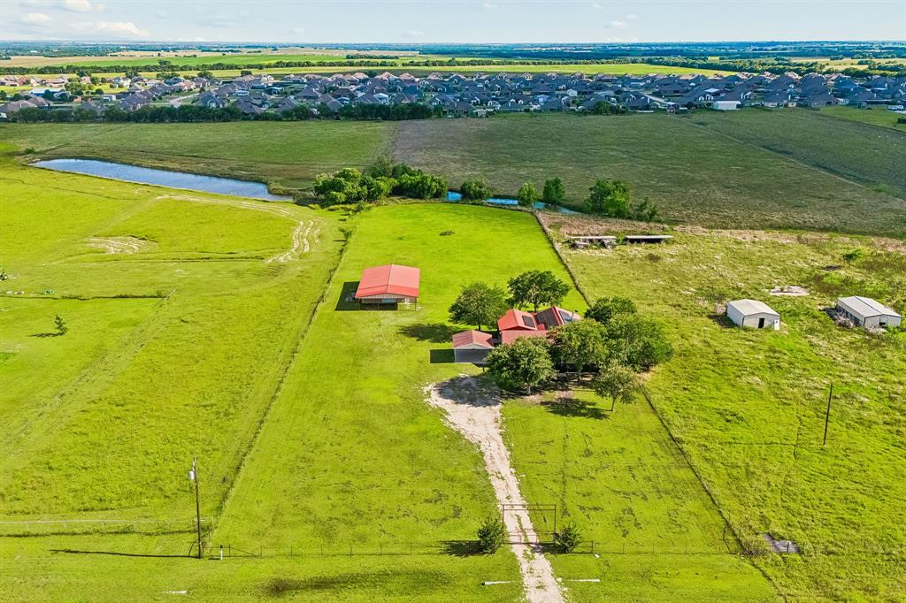 Welcome to your own piece of paradise! Nestled on 2.5 acres in the growing community of Nevada and zoned to Community ISD, this charming north-facing ranch property offers the perfect blend of country living and modern convenience. From the moment you arrive, you’ll appreciate the impressive drive-up appeal featuring an electric iron gate, sprawling acreage, a welcoming wraparound front porch, and a durable metal roof. Step inside to find an inviting open-concept layout designed for comfortable living and entertaining. Just off the entry, the dining area is conveniently located adjacent to the kitchen, creating a warm and welcoming space for gatherings. The kitchen features granite countertops, brand-new stainless steel appliances, abundant rustic pine cabinetry and rustic pine wood flooring leading to the spacious family room. The heart of the home is the stunning family room, highlighted by soaring vaulted ceilings, a dramatic cedar beam spanning the ceiling, and a beautiful gas-burning iron stove that adds warmth and character and above the living room is a versatile loft area that makes the perfect home office, study, reading nook, or flex space. The home offers three generously sized bedrooms, two full bathrooms, and a convenient guest powder bath. The private primary suite is thoughtfully separated from the secondary bedrooms for added privacy. An oversized laundry room with additional storage space provides added functionality. A major bonus is the large shop located on the property, complete with a fourth bedroom and full bathroom. This flexible space could serve as a guest suite, mother-in-law quarters, home gym, hobby room, or private office. Additional highlights include paid-in-full solar panels installed in 2022, providing energy efficiency and long-term savings. Enjoy peaceful country living with room to roam while remaining conveniently close to schools, shopping, dining, and the continued growth of the area.