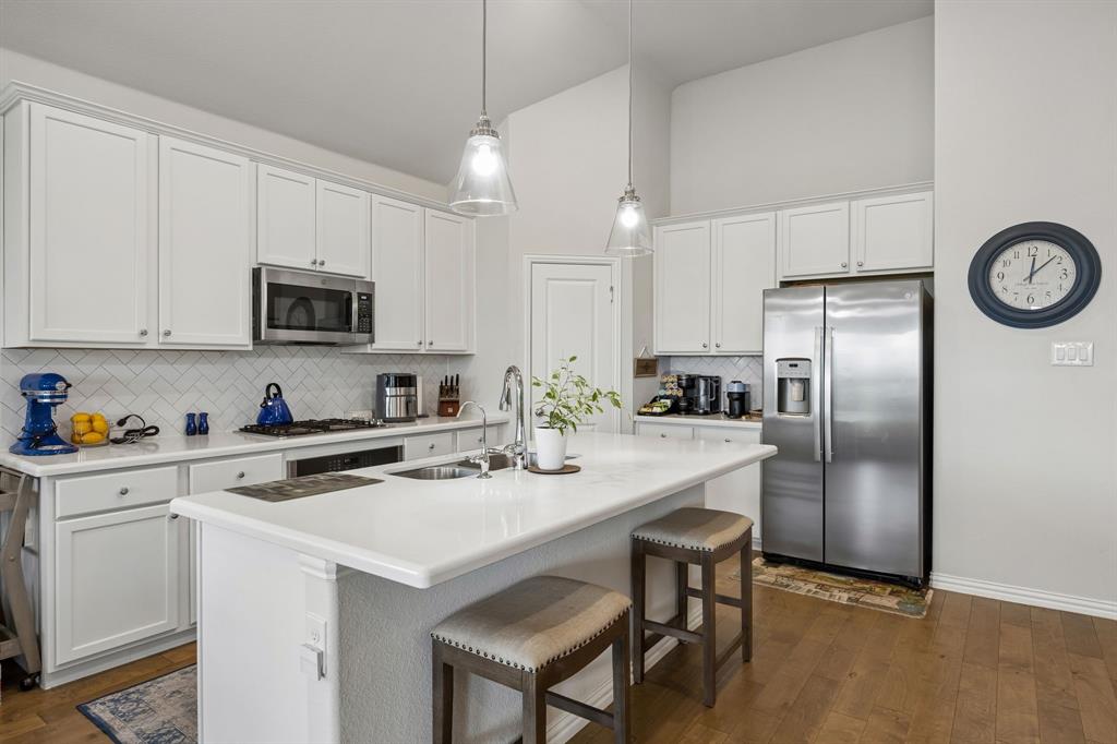 This move-in ready 1-story home at 10324 Lakemont Dr offers 1,998 square feet of refined living space built in 2021, presenting a premium alternative to new construction within an established neighborhood. Positioned for convenient access to major commuter routes with no rail crossings, the intelligent 3-bedroom, 2-bathroom layout prioritizes privacy by separating secondary spaces from the main living areas. The chef-inspired kitchen anchors the heart of the home, featuring a large central island for casual seating, extensive cabinetry, durable countertops, and stainless steel appliances. Flowing seamlessly from the cooking area, the open-concept living and dining spaces are elevated by tall ceilings, an abundance of natural light, and a focal-point fireplace. Secluded at the rear of the layout, the primary suite serves as a quiet retreat with views of the natural landscape. High-end property features distinguish this residence, including a custom steel front door from Love That Door, programmable Jellyfish eave lighting, a steel insulated garage door with a Bluetooth opener, and overhead storage racks. Outside, custom rock and flagstone pathways enhance the curb appeal on a lot that backs directly to an expansive greenbelt with no rear neighbors. The outdoor living area is designed for entertaining, complete with a built-in gas fire pit and a patio pre-plumbed for a grill line. Buyers searching for homes in this vibrant market will appreciate the mature community atmosphere, which includes stocked fishing ponds, miles of paved walking trails, and a community center with a swimming pool. Situated near premier shopping, dining, and employment hubs, this property combines modern upgrades with an exceptional location.