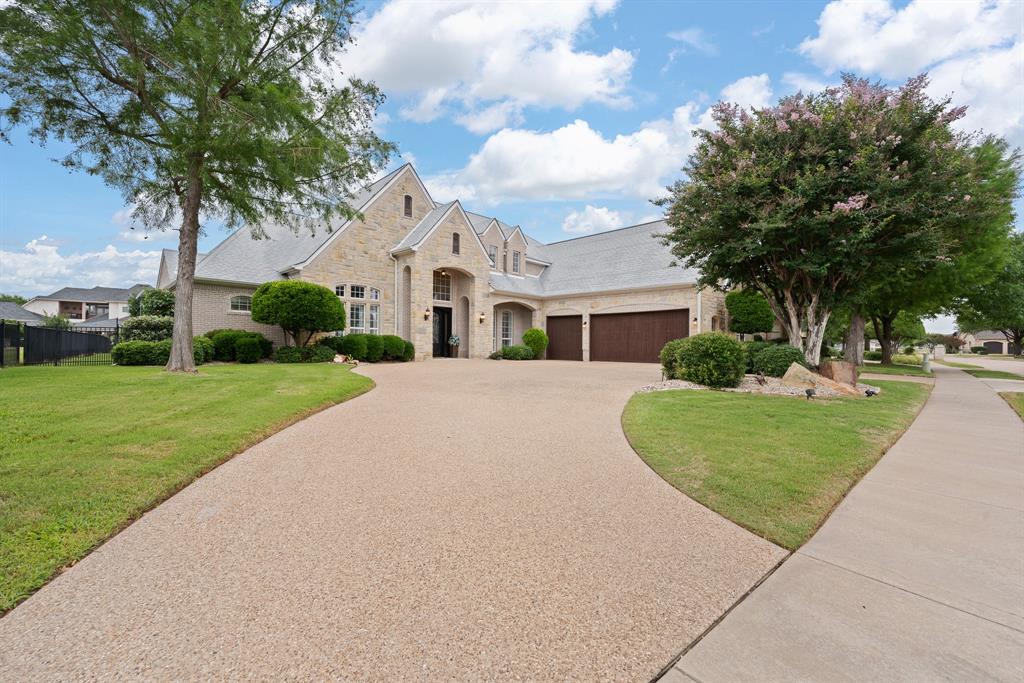 Back on the market! Due to the buyer's failure to perform, the sellers exercised their right to terminate.Experience refined lakefront living in this stunning waterfront home within Harbor Lakes Golf Club. Enter through iron doors into a thoughtfully designed residence featuring four generously sized bedrooms, 3.5 baths, a private office, game room, and media room, offering flexibility for entertaining, relaxing, and everyday living. At the heart of the home, the main living room features an impressive floor-to-ceiling stone fireplace that creates a warm and inviting atmosphere. The kitchen is equipped with stainless steel appliances, a large island with a prep sink, built-in microwave, warming drawer, and a spacious butler’s pantry, perfect for hosting guests or keeping daily life organized. The primary suite serves as a private retreat, featuring dual vanities, a jetted soaking tub, walk-in shower, and an oversized custom walk-in closet. Storage is abundant throughout the home, including a laundry room complete with cabinetry, a utility sink, and a built-in ironing board. Upstairs, you'll find an expansive game room and media room featuring additional cabinetry, a sink, and space for a refrigerator. The fourth bedroom offers access to a private balcony with peaceful views of the pool and lake, creating the perfect place to unwind. Outside, enjoy a resort-style backyard designed for entertaining and relaxation. The pool and spa overlook the water, while the private boat dock and open patio with a built-in grill and smoker make outdoor living effortless. Wrought-iron fencing with a lower safety panel keeps pets secure without obstructing the scenic lake views. Four separate rooms provide direct access to the outdoor living area, seamlessly connecting indoor and outdoor spaces. Additional highlights include a watercraft slip, spacious three-car garage, circle driveway, new flooring throughout the downstairs level, and a new upstairs AC unit installed in October 2025.