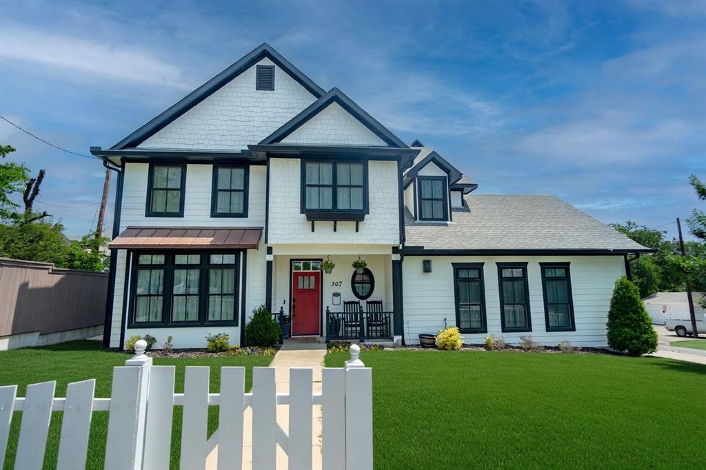 Steps from Historic Downtown McKinney Square – A Rare 2019 Custom Gem
This stunning 2019 custom-built home delivers the perfect blend of small-town charm and modern luxury. Built by the highly regarded British Builder, known for exceptional craftsmanship and timeless finishes, this residence offers quality you can feel the moment you arrive.
Imagine strolling to downtown shops, restaurants, and events, then returning to your own peaceful corner lot sanctuary, framed by a classic white picket fence. Inside, rich hardwood floors flow throughout, complemented by a beautiful farmhouse sink, premium cabinetry, and high-end countertops. Thoughtful details elevate every space: elegant higher-end chandeliers and lighting, luxurious hardware, and solid-core doors that add weight and sophistication.
The oversized garage features 9-foot tall doors to accommodate larger vehicles, plus abundant storage. A striking full-brick chimney anchors the fireplace, adding warmth and character. Upstairs, one bedroom is currently configured as a flexible home office—ideal for today’s lifestyle.
Outside, the beautifully landscaped backyard offers a relaxing pergola, and a fire pit amongst  flowering Magnolia trees, creating a private retreat. Efficiency meets comfort with a top-tier 25 SEER AC unit, delivering whisper-quiet performance and remarkably low utility bills.
Homes of this caliber—custom-built with this level of care and in this enviable walk-to-everything location—rarely become available. Don’t miss your chance to own a true standout in one of North Texas’ most desirable downtown communities.