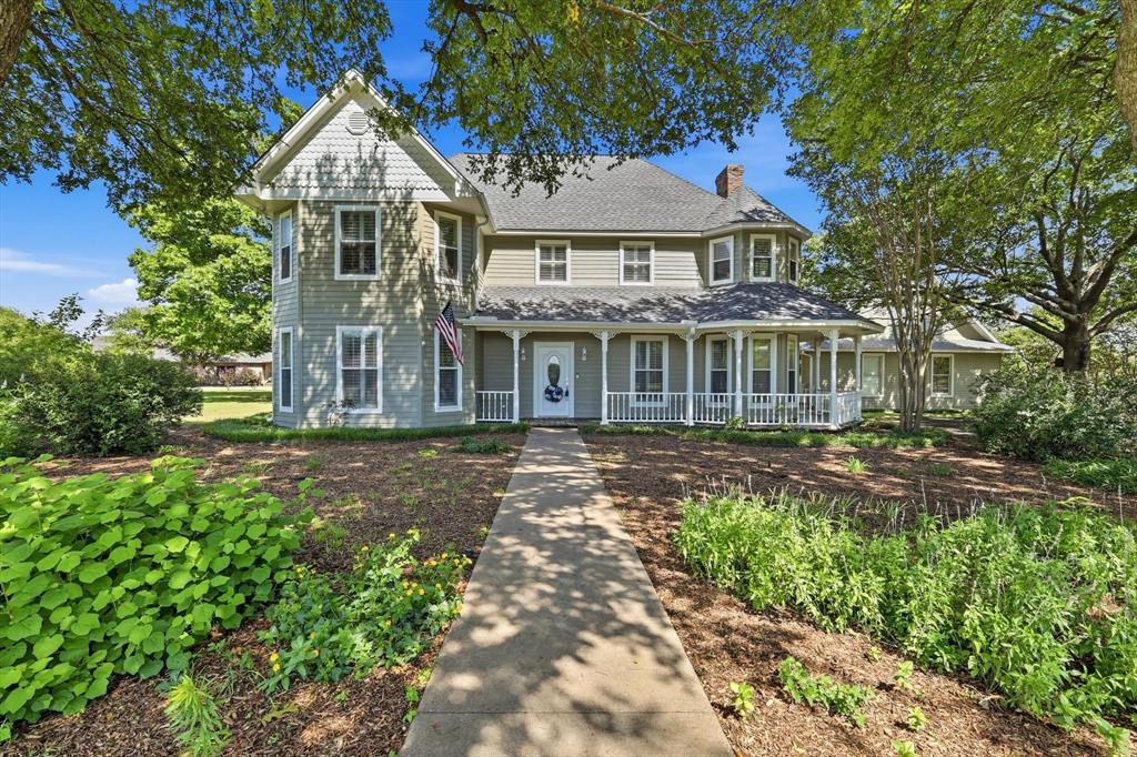Beautiful country Victorian home situated prominently on corner lot of nearly 2 acres in coveted gated Melissa neighborhood! Surrounded by lush wildflower garden and mature trees, this one-of-a-kind property welcomes you with a charming wrap-around front porch and the opportunity to enjoy country-style living—bring your horses and chickens! Recent updates include new roof, smart siding, gutters, garage doors, LVP flooring, carpet, fresh interior and exterior paint, and new cabinets, blending timeless character with modern updates. Inside, enjoy abundant natural light, exquisite light fixtures, custom cabinetry, beadboard wainscotting and plantation shutters. Ensuite master bath with walk-in jet massage tub. Charming kitchen features new butcher block countertops, KitchenAid appliances, an eat-in breakfast nook, unique brick cooking alcove and garden window overlooking lovely yard.  Covered breezeway leads to over-sized 2-car garage with full bathroom and 550 sq ft of additional living space upstairs, ideal for a mother-in-law suite, guest room, or home office.  White picket-fence outlined back yard features mature crape myrtles, iris beds, veggie garden and 8X20 storage shed with full electricity.  Come make new memories in this well-loved Melissa home and experience the highly rated ISD, small-town atmosphere and wonderful neighbors!  Move-in ready!