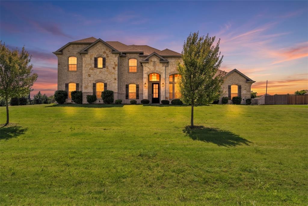 Discover this stunning custom home in Oxford Ranch, perfectly situated on over an acre with no city taxes! The open-concept layout is adorned with elegant wood-plank tile flooring and architectural details like wainscoting, single-stage crown molding, and a wrought iron stair railing. A cozy wood-burning fireplace with a tile-and-wood mantle serves as the focal point of the family room. The gourmet kitchen is a chef's dream, featuring 42-inch prefinished cabinets, Level 2 granite countertops, a tile backsplash, and a full suite of Whirlpool Smart Appliances. The large island, deep stainless-steel sink with a Delta gourmet faucet, and ice-maker connection complete this entertainer's paradise. Retreat to the luxurious primary suite, which offers a spa-like bath with cultured marble vanities, an acrylic drop-in tub with a tile deck, and a separate recessed, mud-tiled shower with a glass door. This home is packed with energy-saving features, including a radiant barrier, energy-efficient Low-E vinyl windows, a zoned Trane AC system, and extensive R-38 ceiling insulation. The exterior impresses with beautiful Acme brick, a full sod and sprinkler system, a 30-year dimensional roof, and an 8-foot glass insert front door. The property is built on an engineered post-tension foundation with piers.