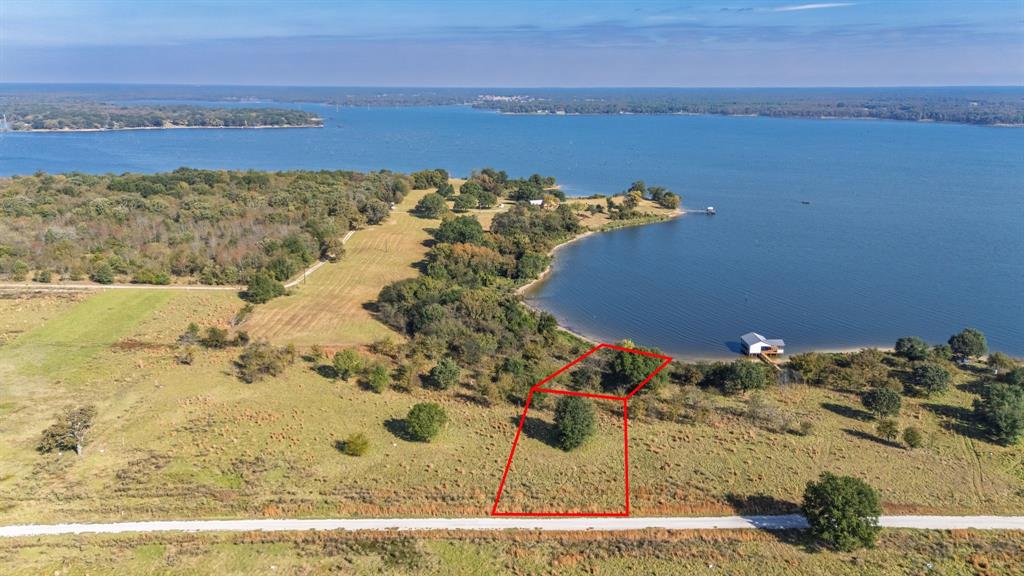 Known as one of the best fishing lakes in Texas, and world-renowned for its trophy bass, Lake Fork attracts anglers and outdoor enthusiasts from across the country. Whether that means casting a line from your private dock, launching your boat for an early morning run, or simply soaking in the view from your porch, this property makes it all possible. Just across the road, you’ll find the private community boat ramp and dock, offering effortless lake access and unmatched convenience. The property is tucked near the end of a peninsula, capturing water views from both the front and back, giving you a front-row seat to some of the lake’s most beautiful scenery. The elevated homesite ensures stunning views and excellent drainage, while the gentle slope to the water provides easy access for a dock or lakeside sitting area. Water and power are available at the road, and the community’s thoughtful restrictions help preserve its peaceful charm and lasting long-term property value. Located just outside Emory, TX, the setting feels private and relaxed, yet close enough to town for all the essentials. It’s a rare balance, country living with modern convenience, surrounded by the quiet rhythm of the lake. Whether you’re looking for a weekend getaway, a forever home, or an investment on one of Texas’s most sought-after lakes, this rare piece of waterfront property is ready to make your vision a reality. Come see why this property offers a place where life naturally slows down and every sunrise reminds you why you’re here