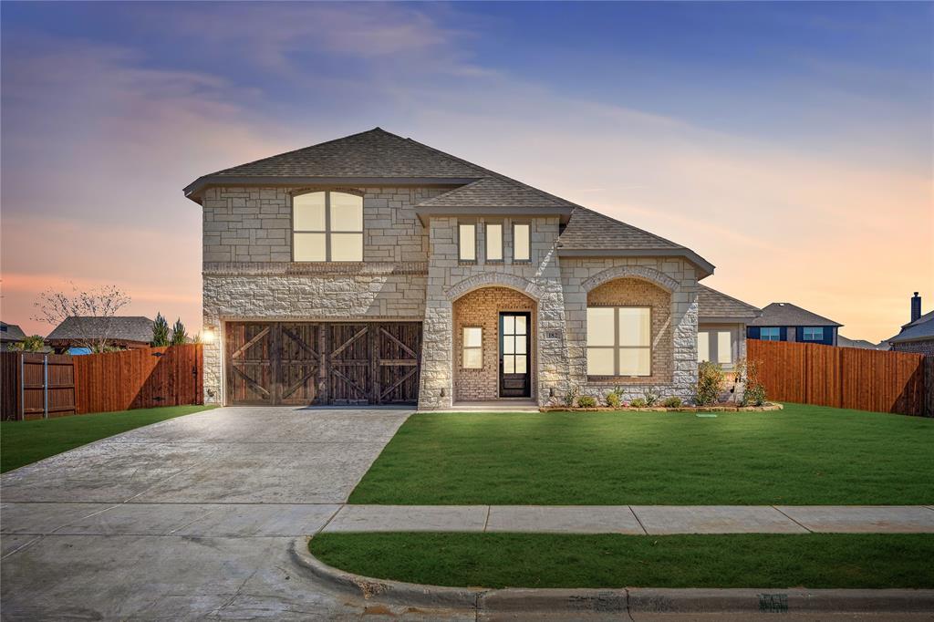 NEW NEVER LIVED IN! Ready NOW. Set on a homesite just over a quarter acre, this Carolina IV by Bloomfield Homes gives you the space you’ve been looking for, in Sunrise Garden Valley. With 4 bedrooms and 3 baths, this two-story design blends flexibility with standout features. A covered front porch opens to a rotunda-style foyer that immediately sets this home apart. Wood flooring runs through the main living areas, leading into a bright family room centered around a floor-to-ceiling tile fireplace. The open layout keeps the kitchen and dining area connected without sacrificing definition. Quartz countertops, built-in stainless steel appliances, and a functional island make the deluxe kitchen practical for daily routines and gatherings. 2-inch faux wood blinds are installed throughout for a clean, finished look. The primary suite is located on the first floor and includes a soaking tub, separate shower, dual-sink vanity, and a spacious walk-in closet. 2 secondary bedrooms downstairs are thoughtfully arranged for comfort and convenience. The second level features a theater-style media room, a spacious game room perfect for family nights, and a large secondary bedroom with access to a full bath. Out back, the extended covered patio overlooks a large backyard. With just over a quarter acre, there’s room to spread out, add a pool, create a garden, or simply enjoy the extra breathing room. Set within Sunrise at Garden Valley in Waxahachie, homeowners enjoy access to greenspace, pavilions, a playground, sports fields, and scenic trails with lake views, all in a community known for its small-town charm and convenient access to schools, shopping, and major highways including I-35E, 287, and 77. Visit the Bloomfield Homes model to learn more about this Carolina IV!