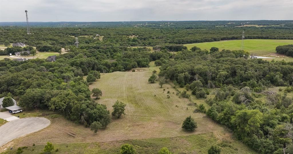 If you are looking for the comfort of community, yet retaining the sense of seclusion and privacy, look no further.  Build your dream home here on these 7 plus acres of Parker County beauty located in the Saddle Crest Subdivision.  Comprised of two lots (lots 52 & 53) located at the back of the subdivision, at the end of a cul-de-sac.  Conveniently located a short distance from FM 51 between Weatherford and Springtown.  This property offers a blank canvas to customize your way with deed restrictions in place to protect your investment.  With approximately 3 acres in open meadow and the balance heavily treed, this tract offers a great balance of open and wooded acreage.  Plenty of room for a home and shop or barn for horses or 4-H projects while still leaving habitat for wildlife.  Set up a deer feeder and enjoy watching wildlife from the comfort of your home.  Build a tree fort for your kids or grandkids and explore the trails in your very own backyard forest.  This is a great property to create the type of space to have family gatherings that the kids and adults alike will reminisce of.  Schedule a private tour today, this property truly cannot be appreciated from the road.