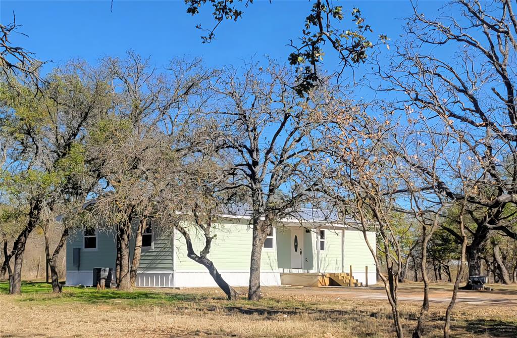 Country life at its finest, beautiful lush trees surround this paradise. If youve been looking for a little privacy, a place where you could raise a few goats or chickens, this is it, youve just found it. This ranch is the perfect getaway after a long days work, it sits between Brownwood & Bangs. The property is adorable, a little over 2 acres, room for the kiddos to roam or raise a few animals.  The home comes with 3 bedrooms, the master has its own bath while the two other bedrooms are roomy and spacious. The open floorplan allows for space to gather, eat in kitchen is convenient and centrally located to the large lving area allowing for family time.  The laundry room sits towards the back of the home and comes with a small mud room. There is a small carport or work shop on the property. However, if your an outside type of person, enjoy nature and enjoy gardening then you will love the beautiful property. You will find the perfect space to place a garden or a peaceful oasis to suit your needs. Come take a look!