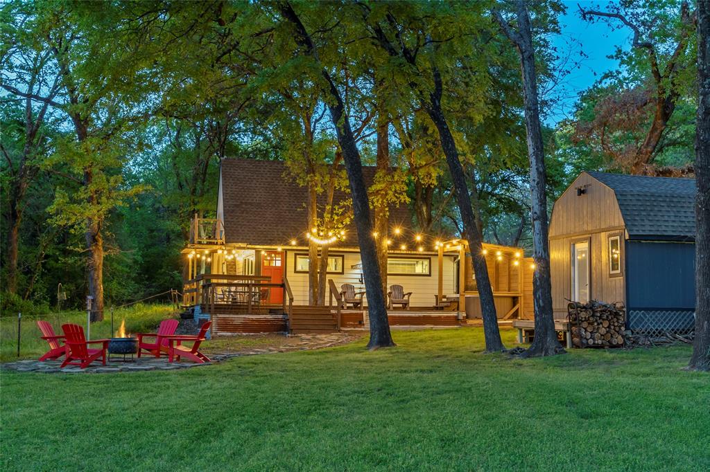 The Best Little A-Frame in Texas—Fully Renovated Waterfront Retreat on Lake Tawakoni! Don’t miss this rare opportunity to own a one-of-a-kind A-frame on Lake Tawakoni, known for premier fishing including trophy catfish, bass, and crappie. Fully renovated from top to bottom, this move-in ready lake home perfectly blends modern upgrades with classic cabin charm. The light-filled A-frame design showcases stunning lake views and an inviting, elevated feel throughout. The primary suite is conveniently located on the main level, while two upstairs bedrooms open to a private balcony, ideal for relaxing and taking in the water views. Step outside to your private outdoor oasis featuring a hot tub with privacy fencing and a fire pit area, perfect for entertaining or unwinding after a day on the lake. The oversized insulated garage offers ample storage, washer and dryer, extra refrigerator freezer, and a dedicated boat plug-in. A detached flex space adds incredible versatility, ideal for a workshop, game room, or gym. Added peace of mind comes with a whole home warranty in place through July 2029, making this property an even more attractive and secure investment. With negotiable furnishings and a proven track record as a successful Airbnb, this property is an exceptional investment. Whether you're seeking an income-producing investment, a relaxing getaway, or a place to call home full-time, this property delivers. Lakefront homes like this are hard to find and highly sought after.