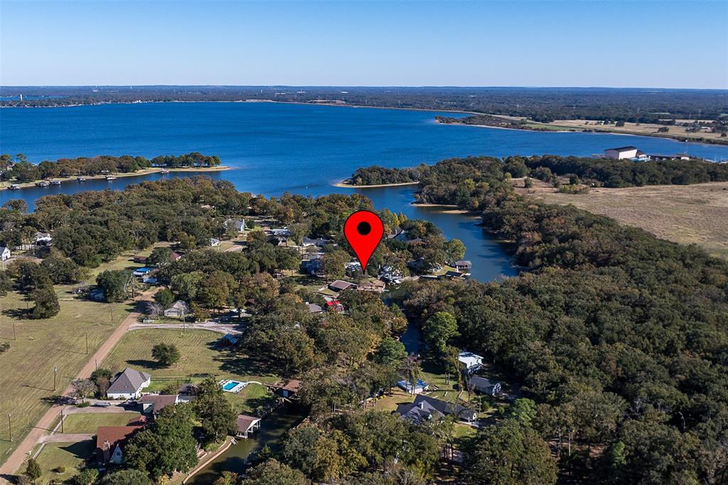 104 Oakcrest Court is a true lakefront escape where relaxed comfort meets the spirit of a classic Texas lake camp. With a protected cove water location in Trinidad, this charming 4-bedroom, 3-bath home offers just over 2,000 square feet of indoor living space designed for effortless lake life. The open-concept layout flows easily from the kitchen and living area to a spacious backyard and waterfront deck built for gathering, grilling, and sunset views. The enclosed shared boathouse is ideal for storing your boat and water toys, or simply unwinding with a fishing pole in hand. Inside, you’ll find a warm, casual atmosphere that captures the nostalgia of lake weekends, with plenty of room for family and friends to spread out and relax. Whether it’s morning coffee on the deck, afternoons on the water, or evenings under the stars, every detail invites you to slow down and enjoy the view. With its protected shoreline, spacious outdoor living areas, and true lakefront access, 104 Oakcrest Court is the perfect blend of function, fun, and timeless lake house charm.