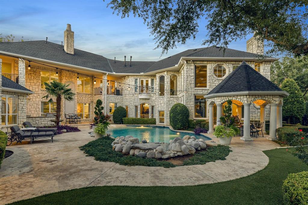 The magnitude of this home can only be fully appreciated in person. This European-style Starwood Estate boasts an entrance that is sure to impress, featuring a large porte-cochère, towering double doors, and a grand two-sided wrought iron staircase upon entry. Open-air catwalks overlook the elegant entryway, formal living room, and dining room. The chef’s kitchen opens into the main living room and showcases a large stone fireplace, double-height ceilings, built-ins, and pool views. Relax in the luxurious primary suite, complete with an oversized en suite bathroom, private study, and state of the art fitness room. Upstairs you will find the remaining bedrooms, movie theater, and an additional primary suite, perfect for guests. This home is an entertainer’s dream, outfitted with a swim-up bar, hot tub, gazebo, sports court, and outdoor kitchen.
