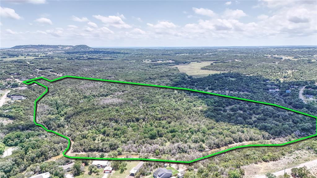 Rare find! Completely untouched and clean land. No easements or zoning in place. Coop Water and Electricity already in place on both sides of the property. Perfect location for a housing development.

Discover an exceptional opportunity to own a stunning 55+ acre parcel of land right outside the Granbury city limits. This expansive property features varied terrain and topography, offering a perfect blend of natural beauty and practical utility.

The land boasts a mix of wooded areas and cleared spaces, catering to various uses and providing breathtaking vistas. A picturesque creek runs the entire northern perimeter of the property, enhancing the natural charm of the landscape and providing a barrier from others. 

Whether you envision a hunting retreat, a thriving ranch, or a new housing development, this property offers unlimited potential to bring your vision to life.