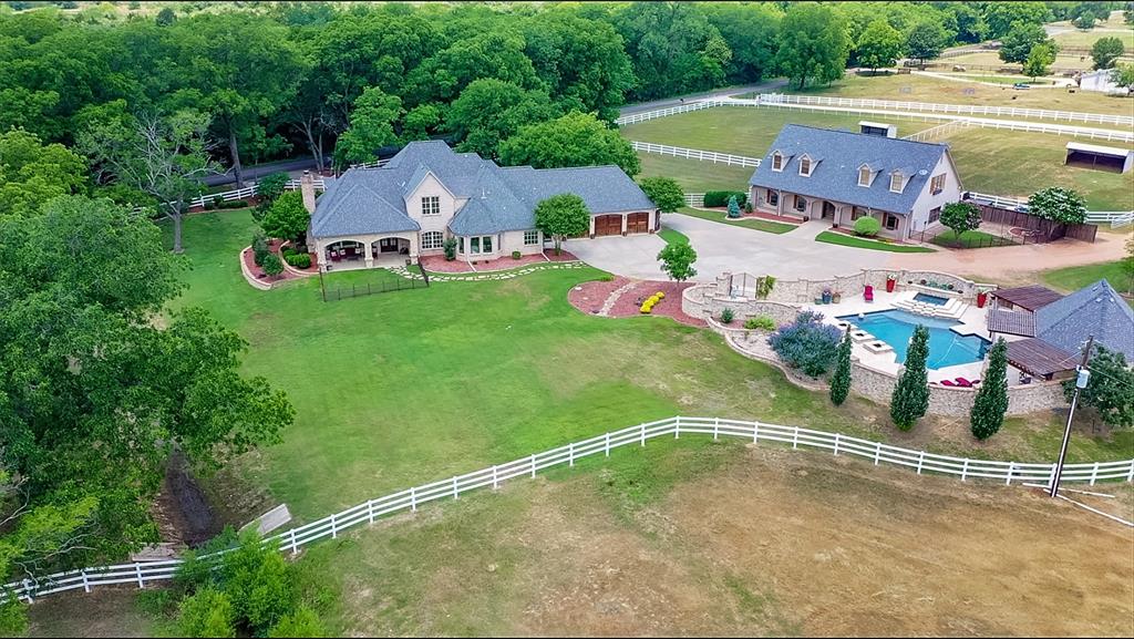 Absolutely stunning! Welcome to this exquisite 38 acre+ french country estate, located in one of the best areas in Denton County. This property offers great privacy, beautiful views and an extraordinary setting!!! Dotted with majestic pecan trees and gorgeous landscaping, it showcases a beautiful and spacious home, a luxurious resort-style pool area with full kitchen and bath, a dry sauna and an oversized three car garage. The estate also includes a large foreman's house, two separate beautifully finished guest apartments, office, climate controlled workshop and storage area large enough for four vehicles, boats, etc. Horse facilities include outside track, horse barns (12 stalls), turn out pens, breeding stocks, tack and feed rooms, two round pens. Land is fenced and cross fenced,large pastures,loafing sheds,two ponds. Water well and Co op water available. Property also has road frontage on Burger road. Located just 2 miles from lake Ray Roberts, one of the prettiest lakes in the USA.