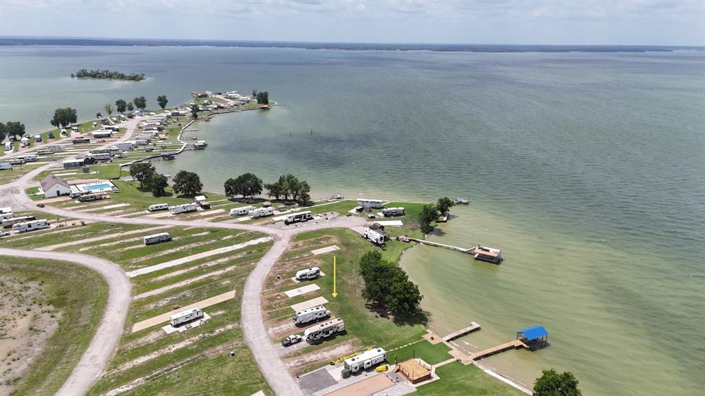 Discover the perfect blend of waterfront relaxation, investment potential, and resort-style amenities with this beautiful waterfront RV lot in Peninsula Point at Richland Chambers Lake. Located within one of the area's premier luxury RV and tiny home communities in Kerens, Texas, this property offers approximately 32 feet of private shoreline and stunning open water views that set the stage for unforgettable sunsets and peaceful lakefront living.

A concrete RV pad is already in place, making it easy to begin enjoying the property right away. Water, sewer, and electric utilities are available at the lot for convenient hookup, allowing you to customize your setup with ease. (Please note that the water tap fee has not yet been paid.) A handful of mature trees provide welcome shade, creating the perfect place to hang a hammock, relax with a good book, or set up a chair and fishing pole just steps from the water.

Whether you're searching for a weekend escape, a full-time lake retreat, or an income-producing investment, this property offers outstanding flexibility. Peninsula Point is short-term rental friendly, making it an excellent opportunity for those looking to generate rental income while enjoying the lake lifestyle themselves.

Residents enjoy an impressive collection of community amenities, including gated and guarded access, paved roads throughout the development, an outdoor clubhouse with a grill station and laundry facilities, a refreshing swimming pool, private boat ramp, limited boat storage, playground, and a convenient pet potty area.

If you've been looking for an affordable way to own waterfront property on Richland Chambers Lake, this improved RV lot offers exceptional value, incredible sunset views, and access to one of the lake's most desirable resort communities. Bring your RV, create your perfect lakeside getaway, and start making memories on the water.