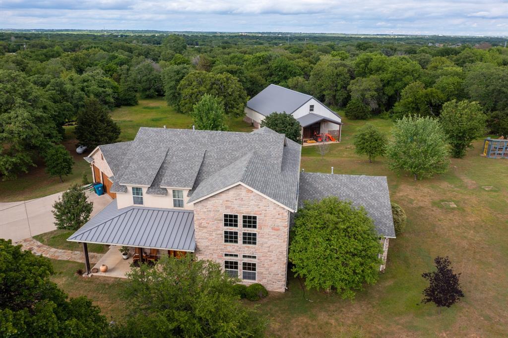 This unique 5-acre ranchette merges country tranquility with city amenities in desirable area of Copper Canyon. An expansive great room, modern kitchen, spacious dining area & loft are fluidly connected and enveloped by a gorgeous hand-crafted Timber Frame creating a haven for relaxation or entertaining. Highly energy efficient home also boasts large master suite, sizable utility room & flex rooms for home office, family room or media area. Custom built-in cabinets, walk-in closets & pantry provide generous storage. Property includes 3-car garage with epoxy flooring, greenhouse and 40x60 BC Steel workshop, 4-stall barn with potential to convert to RV garage or separate quarters. Fenced Pasture for livestock or horses and peach orchard currently qualify for agricultural property tax reduction that can convey. Feeds into Lewisville ISD. Picture yourself in this serene setting with easy access to Lewisville Lake, riding trails, The Shops at Highland Village and many fine restaurants.