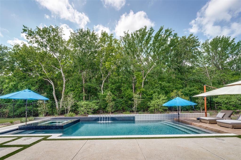 A rare blend of privacy, design, and resort-style living—set within one of Flower Mound’s most exclusive gated enclaves.

Positioned on a premier 0.374-acre greenbelt lot in Sunset Point at Twin Coves, this 2022-built luxury residence offers over 4,100 square feet of thoughtfully curated living space, blending architectural presence with elevated everyday comfort.

From the moment you enter, soaring vaulted ceilings, expansive sightlines, and refined finishes set the tone. The open-concept living area is anchored by a gas fireplace and flows seamlessly into a chef’s kitchen designed for both function and entertaining, featuring a large island, butler’s pantry, walk-in pantry, built-in refrigerator, double ovens, and gas range top.

The private primary suite offers a true retreat with a spa-inspired bath, dual vanities, soaking tub, oversized walk-in shower, and a generous walk-in closet. Two secondary bedrooms include ensuite baths, while an additional upstairs bedroom is positioned near a full hall bath, providing flexible accommodations for guests or multigenerational living. A dedicated office, downstairs media room, and upstairs game room complete the interior experience.

Step outside to a backyard designed for year-round enjoyment. The outdoor living center features a covered patio, built-in grill, and a stunning heated infinity-edge pool and spa with water features and waterfall, all set against a peaceful greenbelt backdrop.

Additional highlights include a three-car garage with, smart home features, and energy-efficient systems, all within a gated, lake-adjacent community.

Homes with this combination of privacy, design, and outdoor living rarely come available—this is one buyers will not want to miss.