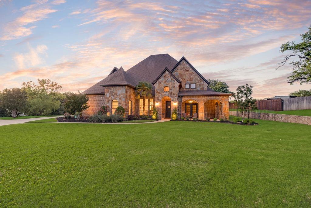 Nestled on just over an acre, this stunning estate offers the perfect blend of luxury, comfort, and privacy. Showcasing beautiful brick and stone curb appeal, a charming wrap-around front porch, and a side-entry 3-car garage, the home makes a lasting first impression. Inside, you’ll find a thoughtfully designed layout featuring 4 bedrooms on the main level, a formal dining room ideal for entertaining, and a dedicated executive study with built-ins. The spacious family room is anchored by a striking stone fireplace and flows seamlessly into the chef’s kitchen, complete with a large seated island, quartz countertops, double ovens, 6 burner gas cooktop, and refinished cabinetry—perfect for everyday living and hosting alike. The primary suite is a true retreat, offering a cozy sitting area and a relaxing ensuite with dual vanities, jetted tub, walk-in shower, and a generous walk-in closet. Upstairs, enjoy endless entertainment in the game room and media room with tiered floor. Freshly painted interiors and new waterproof floors add a bright, updated feel throughout. The Control4 Home Automation system integrates your devices and the alarm system provides peace of mind. Step outside to your private backyard paradise, where a covered patio with fireplace, outdoor kitchen with gas grill and bar seating, and a sparkling heated pool are surrounded by lush green space and mature shade trees—ideal for relaxing or gathering with friends and family. Perfectly positioned near Westlake’s prestigious financial district, the exclusive Vaquero Club, and just minutes from Southlake Town Square, this exceptional property offers luxury living in a prime location. Bonus: horses and livestock are permitted!