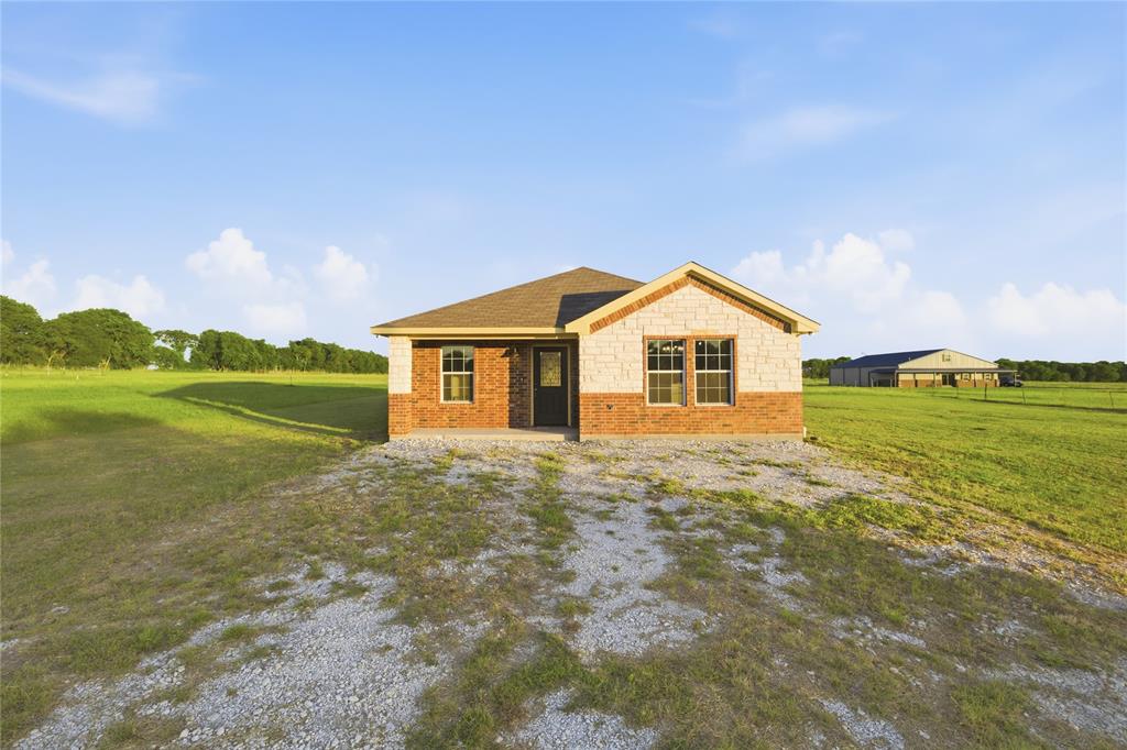 Affordable New Construction on Acreage! Welcome to the country lifestyle—space, privacy, and modern finishes—all on your own approximate 1-acre homesite. Built in 2023, never lived in! This beautifully crafted 3-bedroom, 2-bath home offers the perfect blend of low-maintenance living and country freedom, just a short drive from the Metroplex.  Step inside to an open-concept layout featuring stained concrete floors, granite countertops throughout, and custom wood cabinetry with under cabinet lighting that adds warmth and quality you can feel. The kitchen is designed to impress with stainless steel appliances, ample counter space, and a functional layout perfect for everyday living or entertaining. The primary suite offers a quiet retreat with a well-appointed bath and generous closet space. Outside is where this property truly stands out—almost a full acre of land gives you room to build a shop, park your RV or boat, create a backyard oasis, or simply enjoy the wide-open Texas sky. No HOA - Built in 2023 – energy-efficient & low maintenance - 0.9280 acre lot with endless potential - Easy access to DFW for commuting. If you’ve been searching for a new home with land—without sacrificing style or budget—THIS IS THE ONE!