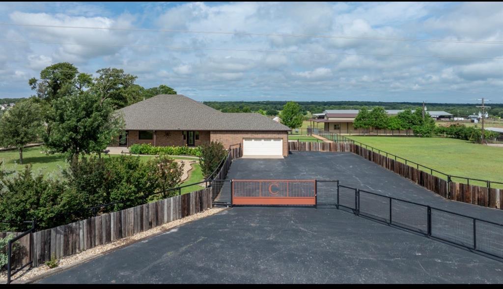 LOW TAXES, LOW UTILITIES, Easy to Show, Come take a look... Experience the perfect blend of country living and modern convenience with this exceptional 11.5-acre estate in the heart of North Texas. Located just 10 minutes from town, an hour from Fort Worth, and a direct route to the Oklahoma state line, this property offers an ideal retreat for those seeking space and serenity. This meticulously maintained, one-owner estate features productive coastal Bermuda and native grass pastures, yielding 50–60 bales annually, perfect for horses, cattle, or any agricultural pursuits. The property is securely fenced with five-foot non-climb fencing, includes RV hookups, and boasts a large equipment shop, making it as practical as it is inviting. The fully equipped five-bedroom, five-bath bunkhouse provides ample accommodation for family or guests. The main home is designed for comfort and style, featuring oak and travertine flooring, an updated kitchen, oversized bedrooms, and a four-season room with a gas fireplace. Expansive covered patios offer handicap-accessible entrances, perfect for enjoying the outdoors.  Additional highlights include an exercise room adjoining the primary suite, a private office with a separate entrance for work-from-home convenience, and exceptional storage throughout. The property is equipped with a private well for irrigation and outdoor needs, while co-op water serves the main house and bunkhouse, ensuring low utility costs with three separate meters.  Recent landscaping enhancements totaling over $75,000 beautifully integrate functionality with curb appeal. This impeccably maintained estate is ready for its next chapter. Shown by appointment only—serious inquiries welcome, as this unique opportunity is waiting for you.  Also, Gorgeous enough to Host Events!!! Weddings, Graduations, Parties, Etc.  Your options are unlimited with the outdoor bathroom and the 5 bed and bath Bunkhouse.  Bring your ideas and make some memories,,,