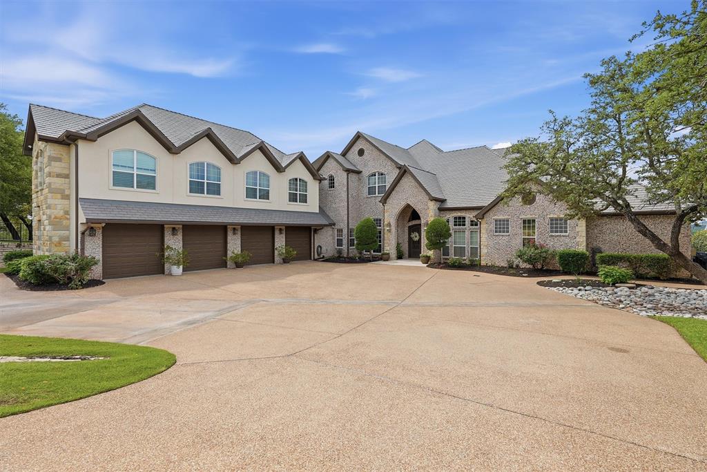 This extraordinary waterfront estate in the prestigious Grand Harbor subdivision offers some of the most breathtaking views on Lake Granbury. Privately situated on approximately 2 acres of prime main-body waterfront, the property blends luxury, privacy, and resort-style living into one truly remarkable offering.
A stunning waterfall entrance and beautiful tree-lined driveway create a grand sense of arrival rarely found on Lake Granbury.
The residence features 7 bedrooms, 5.5 bathrooms, and a spacious 4-car garage, thoughtfully designed for both refined daily living and large-scale entertaining. Expansive indoor and outdoor living spaces capture panoramic lake views throughout the home.
The resort-inspired outdoor setting includes a stunning pool and spa overlooking the water, outdoor kitchen, and an impressive boat dock equipped with multiple slips and jet ski lift.
Inside, the home offers a theater room, climate-controlled wine room, and generous gathering spaces curated for unforgettable entertaining and multi-generational living. A separate bunk room retreat is perfectly designed for hosting family and guests, complete with built-in bunk beds, game room, kitchenette, full bathroom, laundry room, and two nursery rooms, creating an incredible private space for kids and extended stays.
A rare opportunity to own one of Lake Granbury’s most iconic waterfront properties.