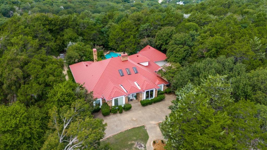 Welcome to 12 Summit Place located in the hills of Cedar Hill! This area, the Summit is the highest point in Dallas County and minutes from Lake Joe Pool.  This exceptional private estate features a circular drive and is situated on a gorgeous acre lot surrounded by a security fence and lots of mature trees. The backyard is an oasis with lush landscape, a covered patio overlooking the sparkling pool and sports court. Walk inside and you are greeted with high ceilings, an open light and bright floorplan showcasing the formal living room with skylights, a WBFP and the formal dining room. This spacious 1.5 story,  4195 square feet 4 bedroom, 4.5 baths and 2 car garage home has room for everyone! There are two master bedrooms on opposite ends of the main floor making the perfect mother-in-law suite or an excellent layout for multi-generational living. The kitchen is light and bright with recent appliances and countertops. The primary master and luxurious bath is extra large with a separate tub and shower,  sitting area and fireplace. The second master has a sitting area, bath and wet bar.  The two secondary bedrooms are spacious as well.  The second downstairs living area is a multi-use oversized sunroom; an excellent space for exercise, meditation or whatever you need it for.  The lone upstairs room is a wonderful large getaway area with lots of built-ins, a bar area, full bathroom and a large balcony overlooking the back of the property. An excellent place to catch early morning sunrises or beautiful evening sunsets.  The home is zoned  with three AC units (two replaced in the last year and the other 2-3 years ago.)  The lifetime metal roof was replaced in 2023. This home has an abundance of storage space. And there is much more to see!