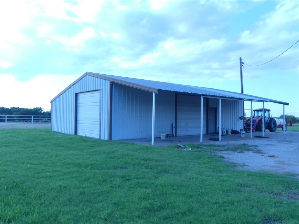 Welcomed by 2 big, beautiful oak trees, you could call this Twin Oaks Ranch. 82+ acres of highly improved pastures. Multiple cross fences. Large, stocked tank. Nice rectangular shape with approx. 1,350 feet of paved county road frontage. Pipe corral with water troughs. 32X48 insulated metal shop with electricity. Shop has 2 10X12 doors and 1 10X10 door. Lots of built-in work benches.  Wired for 220V for welder, big air compressor or other uses.  There is also a 12X48 shed on the side of the shop for parking other equipment. There is an 18X28 building that could be used as a party barn bunk house or other things.  There is an approx. 18X76 singlewide mobile home on the property.  It has an 8X12 covered front porch and a covered metal 10X30 back porch. It is considered to be of no value but could possibly be made livable.  It does have a well and septic system. Don't let this one get away, call your agent today!