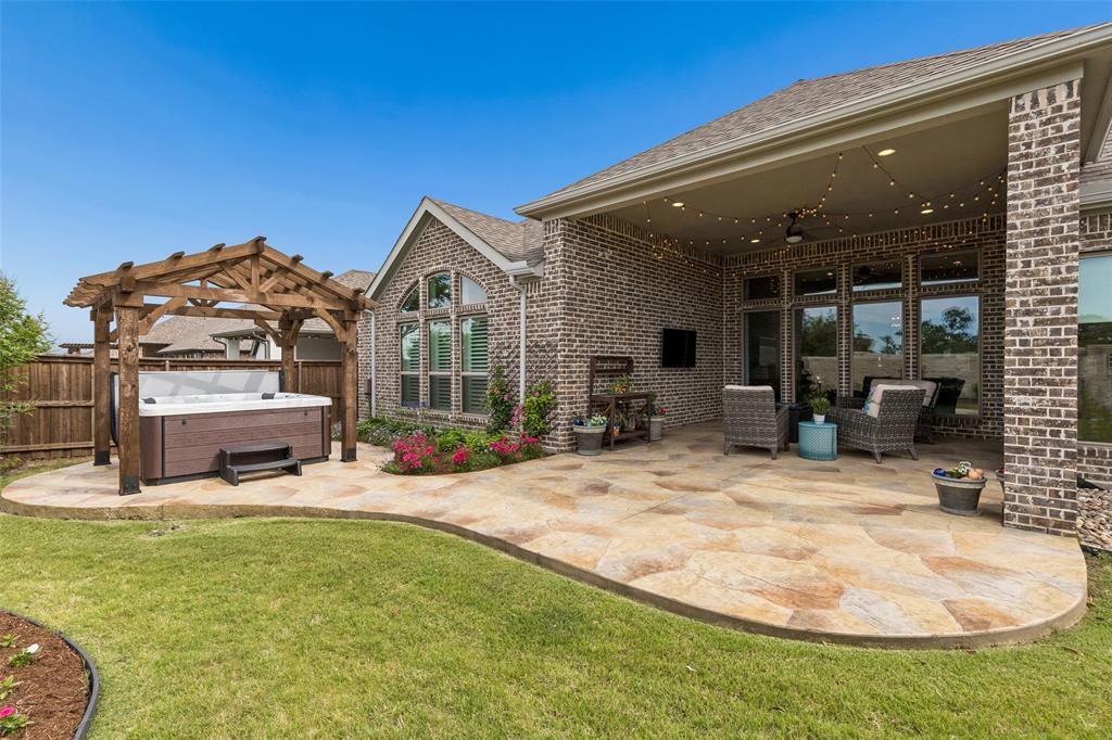 Stunning Perry Home 2916 Plan that with an additional $50,000 after the builder upgrades!Outside enjoy an incredible upgraded covered patio featuring stamped concrete, a ceiling fan, string lighting, and a TV mount designed for year round enjoyment. Just beyond, you’ll find a 6 person hot tub nestled under a stunning standalone cedar arbor, complete with two pumps, an ozonator system utilizing UV light for water purification, interior and perimeter lighting, and a partial warranty creating your own private backyard oasis.This home also includes a powerful 14-kilowatt Kohler whole home generator, offering peace of mind and uninterrupted comfort.This home offers 4 spacious bedrooms and a versatile flex space perfectly suited for a home office, second living area, hobby room, or private workout retreat. The open-concept living room and kitchen create a seamless flow, perfect for everyday living and entertaining.The kitchen is beautifully appointed with quartz countertops,crisp white painted cabinetry,abundant storage,and a generous dining area that easily accommodates gatherings both large and small.Tucked privately at the back of the home, the primary suite offers a peaceful retreat with an ensuite bathroom with his and her closets,garden tub,oversized shower,and his and her vanities.Located in the award winning Trinity Falls community, this home offers an incredible lifestyle surrounded by nature, amenities,and connection.Spanning over 2,000 acres,Trinity Falls was thoughtfully designed around outdoor living with more than 450 acres of open green space,scenic parks,wooded trails,lakes,and gathering areas woven throughout the community.Enjoy multiple pools,splash pads,playgrounds,fitness facilities,event spaces,grilling areas,and community gathering spots at The Club and The Lodge.The neighborhood also features miles of hike and bike trails,tricycle track,disc golf course, og park,fishing lakes, and  access to 350 acre B.B. Owen Park along the Trinity River.