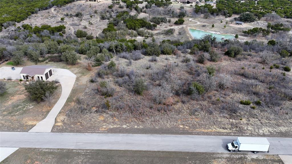 This nearly 2-acre parcel offers privacy, serenity, and the perfect setting for your forever home in a prestigious gated lakefront community near Graford. Located in Palo Pinto County, this approximately 1.9-acre lot, features paved road access within a gated community of high end homes. Electricity and city water are available at the road, city sewer is in place, and mineral rights convey 100%, with title held free and clear. The HOA dues are current, standard utility easements apply, and deed restrictions require a minimum build of approximately 1,800 sq ft with no mobile homes permitted.