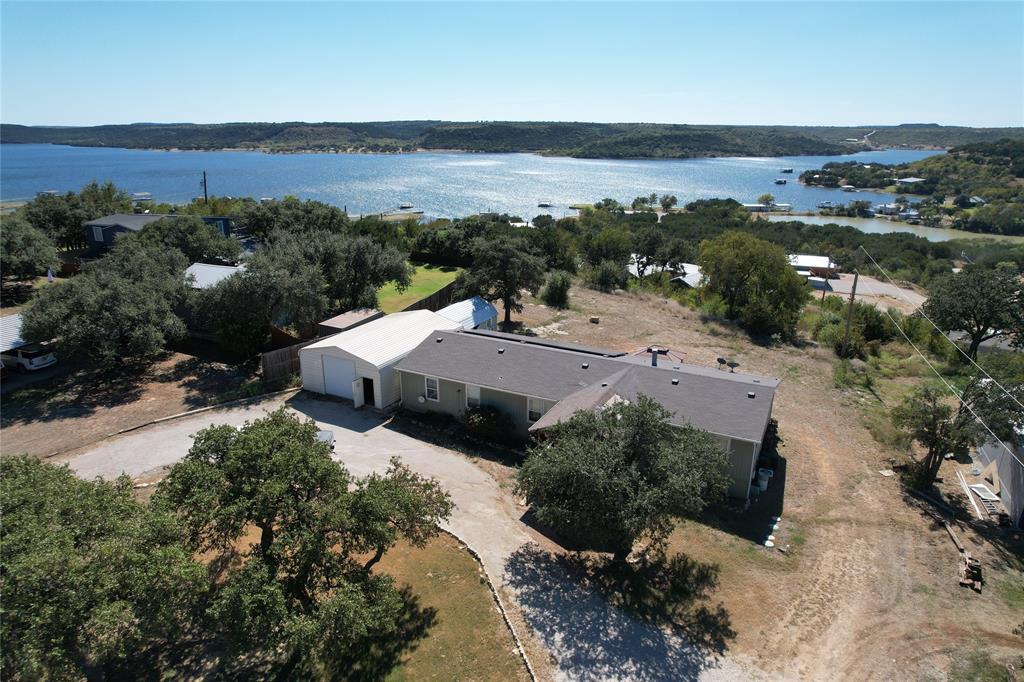 Located on the west side of Possum Kingdom Lake this spacious manufactured home is a great opportunity to dip your foot in the lake life. Just 20 minutes form the conveniences of Graham, and a short drive to Possum & Fox Hollow this home is fully furnished and ready to enjoy or rent. Inside you’ll find an open living area, a practical kitchen with plenty of storage, and four nicely sized bedrooms—ideal for family, guests, or short-term rental use.

Outside features include a 30x30 shop perfect for boat or equipment storage, plus an accessory building complete with a pool table for extra hangout or hobby space. Everything you need for lake life is already here. Also included is an 11x24 carport perfect for additional covered parking or small RFV storage.

Whether you’re looking for a full-time home, weekend getaway, or a functional investment property outfitted for short-term rentals, this one checks all the boxes boat or RV carport all sitting on just over an acre of deeded land with an excellent elevated lake view! 

Additional Info: Home has 24 solar panels installed on the roof to help with the energy costs.