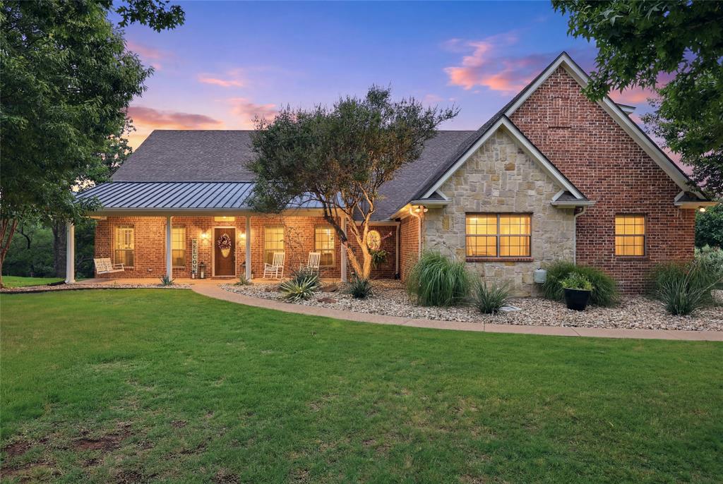 Located within the GATED GOLF COURSE COMMUNITY of The Reserve at Sugartree, this beautifully maintained 4-bedroom, 3-bath home offers comfortable living, inviting outdoor spaces and a backyard designed for relaxation. Attractive curb appeal and a spacious front porch, complete with a porch swing and room for additional seating create a welcoming first impression and a peaceful place to enjoy the surroundings.

A private office-den with custom built-ins and pocket doors provides an ideal work-from-home space. The spacious living room features a fireplace and opens to the kitchen, creating a comfortable setting for everyday living and entertaining. The kitchen offers generous cabinet and counter space, a breakfast bar, and easy flow to the dining room and breakfast area. Rich hand-scraped hardwood flooring extends through the entry, office, and dining room, while engineered wood flooring enhances the family room. The primary suite offers private access to the covered back patio. A versatile upstairs suite with a private full bath provides flexible living options and is ideal for guests, a game room, media room, or multi-purpose space. The 3-car garage includes a workbench area along with additional storage and project space.  Designed for year-round enjoyment, the backyard features a sparkling in-ground pool and spa, tanning ledge with bubblers, oversized covered patio with remote-controlled shades, pergola, firepit area, and a spacious grassy area for play, pets, or outdoor activities. Situated on a beautifully treed half-acre lot with terraced landscaping, the backyard offers privacy, scenic views, and frequent visits from local wildlife.  Located in Brock ISD, this property offers a peaceful country setting with convenient access to shopping, dining, and everyday amenities. A complete list of upgrades and features is available in Transaction Desk.