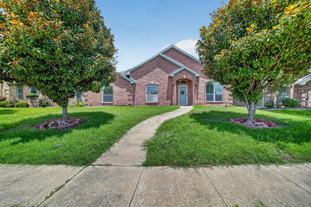 Welcome to 909 Trinity Drive, a beautifully maintained single-story brick home offering 2,043 square feet of comfortable living in Lancaster's established Westwood subdivision. Built in 2007 and set on an interior lot with mature trees, this 3-bedroom, 2-bath residence delivers a smart, open layout designed for everyday living and easy entertaining. The spacious living room features a cozy gas-log fireplace and ceiling fan, flowing seamlessly into a chef-friendly kitchen complete with a center island, breakfast bar, built-in cabinetry, dual sinks, a walk-in pantry, and an eat-in dining area. A separate formal dining room, oversized dedicated home office, and flexible den provide room to work, host, and unwind. Retreat to the generous primary suite featuring a walk-in closet, and a spa-like ensuite bath with a jetted garden tub, separate shower with body sprays, and dual sinks. Thoughtful touches throughout include decorative lighting, wainscoting, a dry bar, double vanities, bay windows, and ceramic tile and carpet flooring. Enjoy Texas evenings on the covered front and rear porches overlooking a private, wood-fenced backyard. Additional highlights include a rear-entry 2-car garage with epoxy flooring and alley access, rain gutters, and a low annual HOA. Conveniently located in Lancaster ISD with quick access to major routes—schedule your showing today.