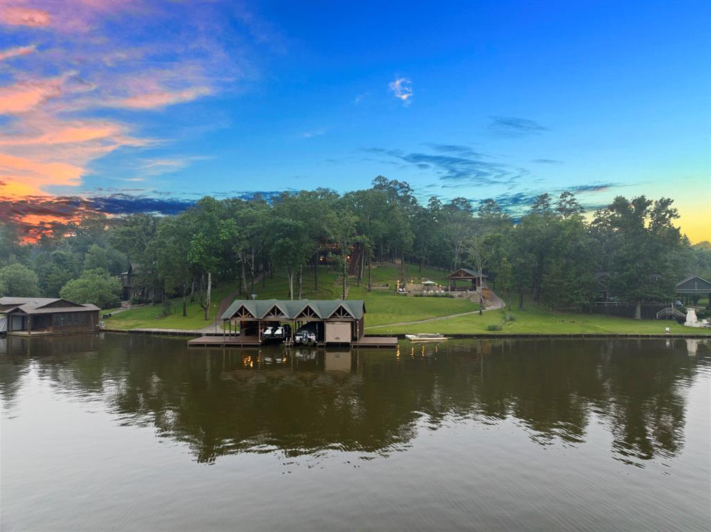 Nestled on over 2 acres of meticulously landscaped grounds, this waterfront estate on Lake Cypress Springs in the Lands End subdivision is a true masterpiece of luxury living. Spanning 3 levels, this custom-built home offers a seamless blend of sophistication & comfort. The main level features a spectacular great room with floor-to-ceiling windows capturing stunning lake views, a gourmet kitchen & dining area ideal for hosting gatherings, & a luxurious primary suite with a spa-like ensuite bath. Upstairs, 2 guest suites with ensuites provide privacy & comfort for visitors. The lower level is designed for entertainment, offering a state-of-the-art media room, spacious bedroom,& bunkroom for guests. Outside, a wrap-around porch offers a perfect spot to enjoy the sunset, while the pool & cabana area with a built-in kitchen & fireplace provide the ultimate outdoor retreat. A fully-equipped boat house with tanning decks & multiple watercraft lifts completes this exceptional lakefront oasis.