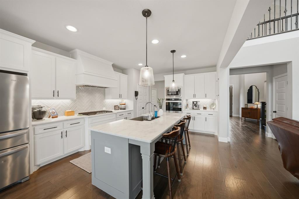 Step into style, space, & sophistication in this stunning 2021 built home offering approximately 3,353 sq. ft of thoughtfully designed living. Perfectly positioned on a desirable corner lot in the sought after Berkshire Richmond Community of N. Ft Worth, this 4 bedrm, 3 bath, designated office which also has a removable partition, mudrm, guest bedrm down, & 3 car tandem garage is a rare gem to find & will check every box. From the moment you enter, you will notice the elevated finishes & modern touches throughout. The high ceilings w beaming natural light through the windows from living rm w brand new remote controlled shades showcases the crisp white kitchen is totally a true show stopper, featuring an oversized island, elegant herringbone backsplash, gas cooktop, coffee & wine bar. The open concept layout flows seamlessly into the living area, highlighted by a cozy gas fireplace & walls of windows that frame serene greenbelt views and the outdoor paradise. Primary suite conveniently located on the first floor offers a luxurious retreat with a beautifully designed modern ensuite bath. Upstairs, enjoy endless entertainment w a spacious game rm & dedicated media rom perfect for movie nights & hosting guests. Step outside to your backyard oasis complete w an oversized covered patio & a gorgeous Gunite sparkling pool, all backing to a peaceful greenbelt where you can unwind and take in breathtaking Texas sunsets. Loaded with upgrades galore & designed for both comfort & style, this exceptional home blends luxury living w everyday functionality in one of the area's most desirable neighborhoods that offers an amazing pool, playground, catch release fishing, walking biking trails, & paint a rock & add it to the painted ROCK SNAKE trail. This LOCATION is amazing & is in the desirable Northwest ISD & is super close to Costco, Target, Alliance Town Center shopping including restaurant choices to savor your flavor. This home won't disappoint so don't let this one slip away.