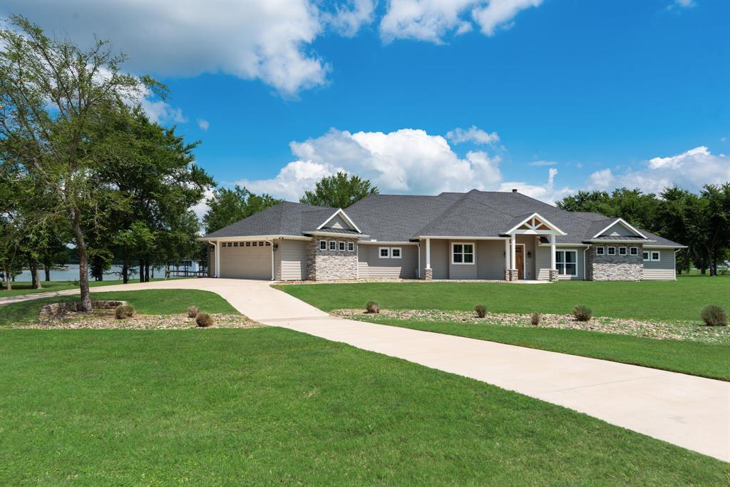 Built in 2023, this 4 bed, 4.5 bath custom waterfront retreat combines luxury finishes, thoughtful design, & nearly 5 acres of privacy on Richland Chambers Lake. With 3,308 sqft of open-concept living space, the home includes 2 lakefront primary suites with private patio exits & custom touches throughout include engineered hardwood flooring, designer lighting, glass door knobs, shiplap accents, pocket doors, & ADA-friendly 3-foot-wide doorways. The kitchen was designed for both entertaining & everyday living with Café appliances, an oversized built-in refrigerator and freezer, quartz countertops, a quartzite island with pop-up outlets, & a spacious walk-in Butler’s pantry. The large laundry room features tons of storage & washer, dryer and extra fridge are included! A wood-burning fireplace with dedicated thermostat helps efficiently heat the home during cooler months.

Built with quality & efficiency in mind, the home includes spray foam insulation, LP SmartSide siding, a post-tension slab foundation, 2 HVAC systems, 2 tankless water heaters, a buried owned 500-g propane tank, & a wired 24kW Generac generator. Additional exterior upgrades include gutters and a bug misting system surrounding the home.

Outside, the property is fully fenced with a freshly painted electric gated entry & fence, mature shade trees, landscaping, sprinkler system, & a spacious back patio overlooking 393 ft of protected cove shoreline. The dredged boathouse includes one boat slip, 3 jet ski lifts, a sink, & storage closet for easy lake living. The property also features an oversized 2-car garage with interior storm shelter, an approximately 1,100-sqft insulated workshop with 2 roll-up doors &  climate-controlled attic storage, plus an attached approximately 400-sqft efficiency apartment ideal for guests or rental use. With no HOA, horses allowed, & both short-term and long-term rentals permitted, this property offers a rare blend of flexibility, acreage, & waterfront living.