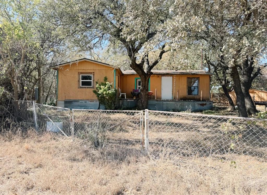 Investment opportunity with endless potential! Situated on just over half an acre, this 3-bedroom, 1-bathroom home offers approximately 820 square feet of living space and is ready for its next owner to make it their own.

The property is fully fenced and includes a small storage shed, as well as an approximately 600-square-foot shop complete with electricity, a walk-through door, and a roll-up door. Whether you're looking for a workshop, hobby space, additional storage, or a place to tackle your next project, this versatile building offers a variety of possibilities.

The home does need some updating and repairs but was recently occupied and has only recently become vacant, making it a great opportunity for investors, flippers, or buyers looking to add value over time. Conveniently located just outside of town and only a short drive from Lake Brownwood, you'll enjoy the perfect balance of country living with easy access to nearby amenities.

Property is being sold AS IS, WHERE IS. Buyer to verify all information, including but not limited to square footage, acreage, schools, and any other information deemed important.