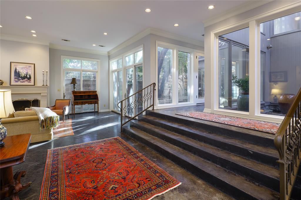 Tucked away in the quiet, gated enclave of Glen Lakes, this beautifully crafted soft contemporary home is an architectural haven nestled among the trees, thoughtfully designed to celebrate seamless indoor-outdoor living. Private front courtyard entry opens to light-filled living and foyer with vaulted ceilings, cast-stone fireplace, wet bar, scored stone floors, and walls of windows creating a treehouse-like feel. Landscaped courtyards extend the living areas for effortless entertaining. The kitchen features a large island with 6-burner cooktop, wood cabinetry, stone backsplash, stainless appliances, walk-in pantry, and eat-in breakfast room. Hardwood floors throughout the second level. Primary suite offers vaulted ceiling, fireplace, Juliet balcony, spa-style bath with separate dressing areas, soaking tub, travertine shower, and three walk-in closets. A spacious secondary living room with built-ins, wet bar, and fireplace, along with two additional ensuite bedrooms, completes this private upper level—each space thoughtfully designed to capture natural light. Residents of Glen Lakes enjoy a park-like setting with lighted walking paths, ponds with water features, a pet park, and convenient walkability to the community pool, tennis courts, and pickleball courts.