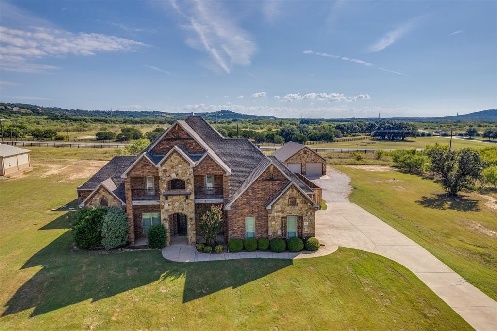 Large backyard and great location! Add a pool, putting green, volleyball, pickle ball, horseshoes, cornhole, and anything else you can imagine! With 6 bedrooms and 5 bathrooms there's room for everyone. This super functional home could also be 5 bedrooms with an upper level flex space. Plenty of room inside and out. It comes with all appliances including a new refrigerator and is partially furnished. The roof was replaced in 2024.  Special touches are scattered throughout this beautiful home and blend perfectly with the comfort it offers. While the spacious open design creates an entertainment headquarters for the home, the square footage offers spaces for individual quiet time. It has a private office with built-in cabinetry that can double as a library. A covered balcony provides the ideal place to enjoy the much talked about sunsets at PK Lake. The large backyard is fenced for privacy and the covered patio has a wood burning fireplace. A great place to gather! This home is located within walking distance to premium amenities including an awesome infinity pool overlooking the lake, the clubhouse and fitness center, and Ritchie's cabin where there's a boat launch and dock. The view of the lake is gorgeous here and this is also an excellent place for paddle boarding. Bring all of your lake toys. The property has a 1500 sq ft shop as well as an oversized garage, and has a 50 amp RV hookup.  Don't miss the opportunity to own this Memory Maker property! Schedule a showing and a private tour of The Hills Above Possum Kingdom Lake today!