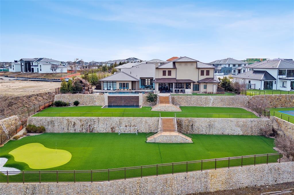Experience true Indoor Outdoor Living in this exquisite hilltop home on 1-acre lot in gated, guarded Hills of Kingswood. Incredible views from breathtaking floor to ceiling windows of the living room onto the 2-level Infinity Edge pool with grotto & spa leading down to fully turfed lawn with putting green & sandtrap. Entertain friends & family in the opulent Casino Royal inspired bar and game room with retractable metal doors leading to an outdoor living area that includes outdoor AC system, built-in grill & outdoor fireplace. Inside kitchen boasts La Cornue range & hood, large entertaining island and prep kitchen. Coffee bar leads to formal dining featuring a humidity controlled wine room with glass doors. Indoor Basketball Court with wet bar and separate exercise room for the ultimate sports lifestyle. Serene primary suite features fireplace, hidden projector tv, glass doors leading to pool, luxurious spa-like bathroom with his and hers custom closets and access to secondary office.