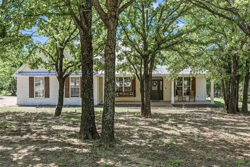 Welcome to your own slice of country paradise in Alvord! Nestled on 2 beautiful acres outside city limits and located in sought-after Alvord Independent School District, this charming and cozy farmhouse offers the perfect blend of modern updates, functionality, and peaceful Texas living.

This updated 3-bedroom, 2-bath home features an open-concept layout filled with natural light from the large windows throughout the home. The spacious kitchen is a dream for cooking and baking, complete with plenty of prep space and a warm, inviting feel that makes the heart of the home truly special. Just off the main living area, you’ll find a stunning built-in coffee bar with custom cabinetry, which is the perfect spot to start slow mornings while overlooking the property.

Step outside and enjoy two massive covered porches, one in the front and one in the back, surrounded by mature trees and serene country views. Whether you’re sipping coffee at sunrise or enjoying the incredible star-filled Texas nights, this property was made for peaceful outdoor living.

The land is fully fenced and features an automatic gate for added privacy and convenience. Animal lovers will appreciate the chicken coop and multiple animal enclosures that will convey with the property.

A standout feature is the large workshop complete with spray foam insulation and electricity which is ideal for hobbies, storage, projects, a business, or future expansion possibilities.

If you’ve been searching for a charming country property with character, updates, functionality, and room to breathe, this Alvord gem is one you won’t want to miss.