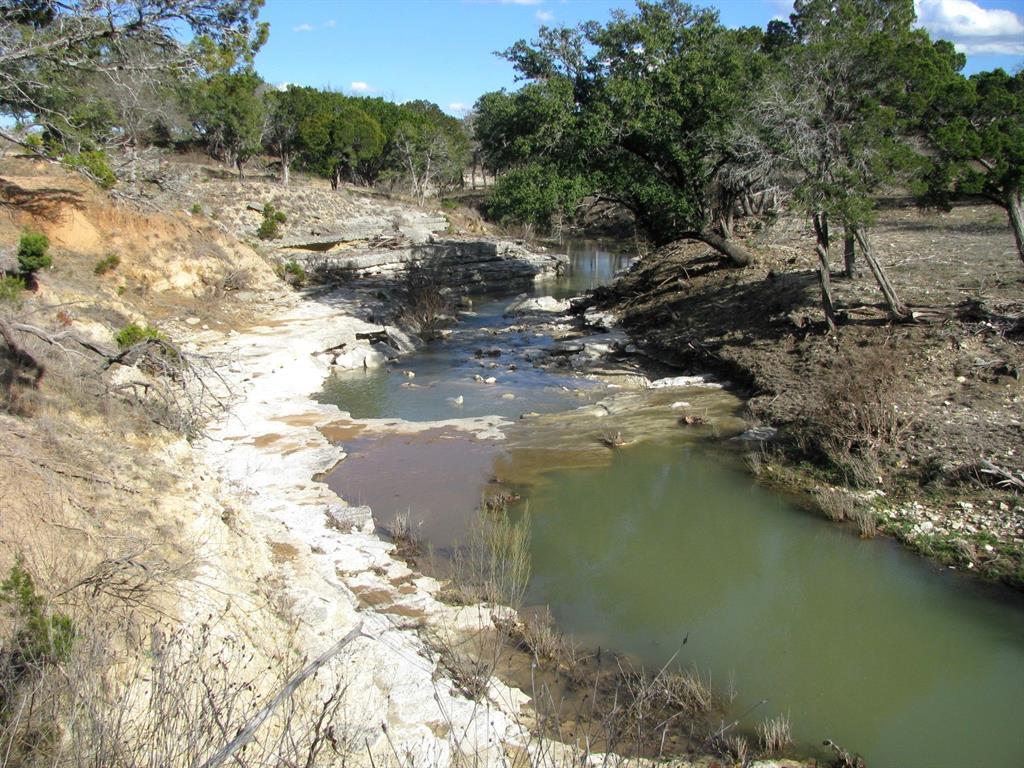 This 5.01-acre tract is located in the gated Buffalo Creek Subdivision, known as lot 64, offers a peaceful setting with paved roads, rolling terrain, and a mix of mature trees. The property features frontage along Langford Creek, providing a scenic and serene backdrop ideal for a homesite or weekend retreat. Electricity and high-speed fiber optic internet are available, and a private water well will need to be drilled. Centrally located, this property is just 30 minutes from Hamilton, Lampasas, and Gatesville, and about an hour from Waco and Stephenville, making it a convenient escape with easy access to surrounding towns. Whether you're looking to build your dream home or invest in land with natural beauty and modern infrastructure, this property presents an excellent opportunity in a well-maintained rural community.