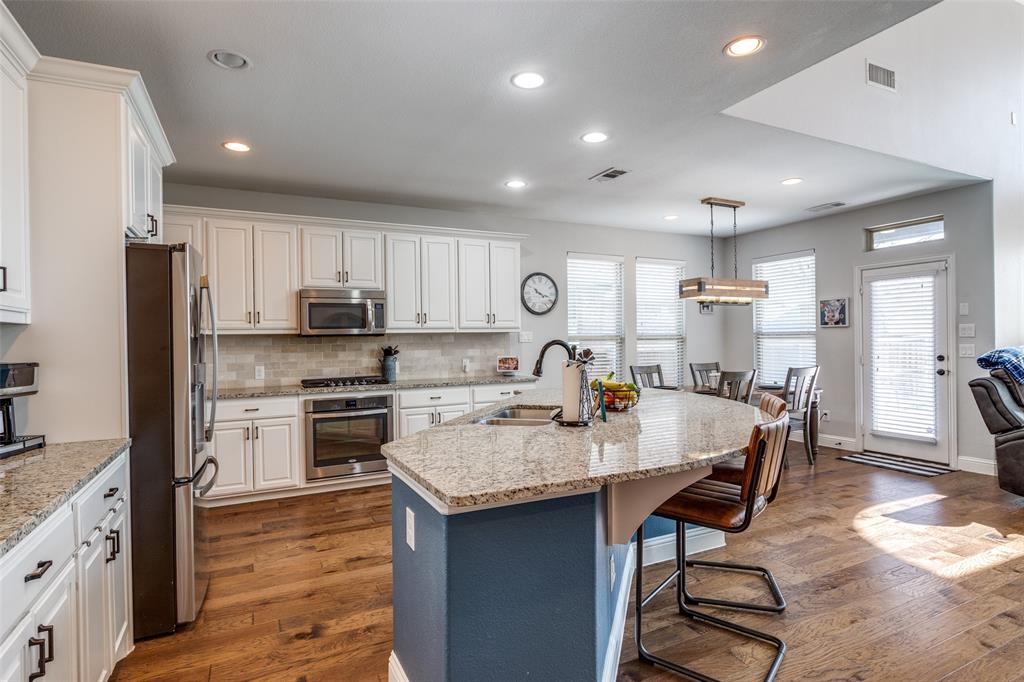 This exceptional home is packed with high-end upgrades and plenty of charm! Featuring gorgeous wood floors, a spacious open kitchen with granite countertops, white cabinetry, a massive island, a 5-burner gas cooktop, stainless steel appliances, and a stylish bar area with a wine fridge.  Eye-catching shiplap accent walls and decorative lighting add character. The extended patio provides the perfect spot to relax and enjoy the beautiful backyard. Versatile flex room with French doors can serve as a fourth bedroom or a private home office. Upstairs, you'll find a cozy living area along with two generously sized bedrooms and a full bath featuring double sinks. Located in the vibrant Trinity Falls community, residents enjoy miles of scenic walking and cycling trails, a resort-style pool, a dog park, serene lakes for fishing, and exciting monthly events for all ages. Don't miss the chance to call this incredible home and neighborhood yours—schedule a showing TODAY!