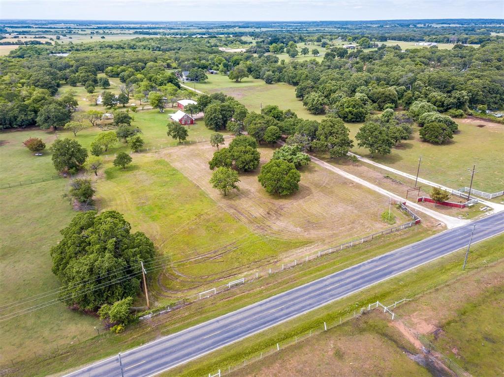 Welcome to almost 13 acres of beautifully treed land and wonderful pasture for your horses, cattle, etc. This property boasts an adorable cottage and limitless opportunities for expansion to the existing home or space to build your dream home. The current home is a two bedroom, one bath with full washer, dryer hook ups, and an open kitchen with island and granite countertops. The metal roof ensures many years of low maintenance and low cost care. With a full RV hook up and 50‘ x 30‘ shop, there is room to roam, space to live while you build, or amenities to accommodate friends and family in sought after Hill County. The addition of a fully functional laundry room with utility sink in the shop, tankless hot water t0 the home, and brand new ductless HVAC are just a few of the recent improvements. This property is just ready to make your country living dreams come true. The property is already cross fenced for future agriculture tax exemption.