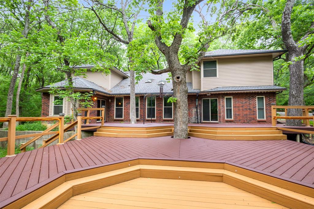 You know that feeling when you pull into Broken Bow? Windows down. Trees closing in overhead. Serene and untouched by municipal influence.
Now imagine that — but you never left DFW.
Sitting on 2.5 acres of the most heavily wooded, canopied land you'll find inside the metroplex, this home is something that simply doesn't come available in these parts. 
An enormous tiered deck spans the length of the house and hangs directly over a babbling creek. This is your backyard.
Inside, a step-down living area framed by oversized windows and skylights immerses you in the tree line from every angle. The home doesn't compete with the outdoors — it invites it in. An updated kitchen delivers granite countertops, generous island and cabinet space, and room to spread out. The owner's suite features a slider that opens directly onto the rear deck, because even your morning routine should come with a view.
The layout is intentional. Each room is its own space — defined, private, and purposeful. Upstairs, generously sized bedrooms flank a central game room, and an unfinished bonus room is ready to become whatever you need — an office, a gym, a fifth bedroom.
From the spacious circle drive out front to the creek beneath the deck out back, every inch of this property is designed around one thing: drawing you outside.
This isn't a home you commute back to. It's a home you escape to without ever leaving civilization.
Rarely available. Impossible to replicate. Available now.