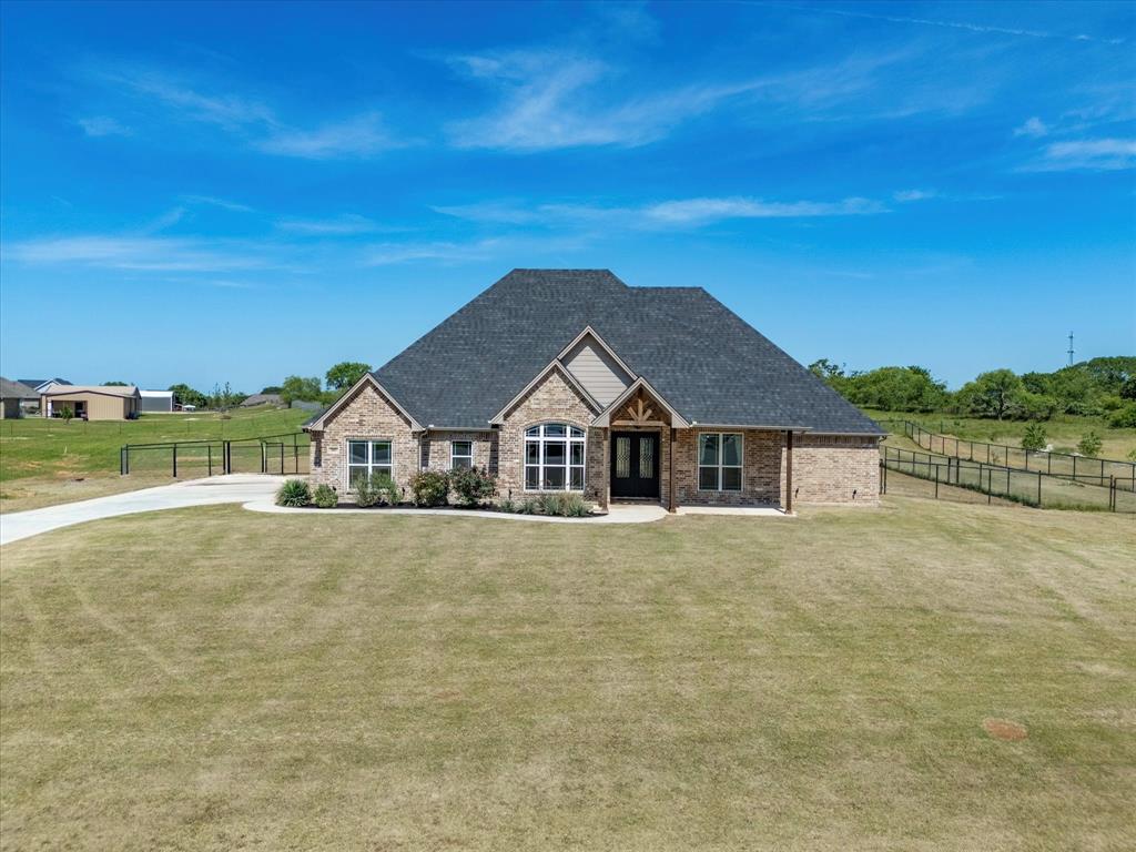 Welcome home to Friendship Ranch in Boyd, Texas! This beautiful 3 bedroom, 2.5 bathroom brick and stone home sits on 1 acre and offers the perfect blend of comfort, function, and style. Inside, you’ll love the open kitchen and dining area, designed for gathering, entertaining, and everyday family time. The kitchen features a large island, granite countertops, stainless steel appliances, and plenty of cabinet storage. The spacious living room offers an electric fireplace, ceiling fan, and room for the big cozy couch you’ve been dreaming of. The primary suite is a true retreat with an en-suite bathroom featuring a soaking tub, separate shower, dual sinks, and a large walk-in closet. Two additional bedrooms share a Jack and Jill bathroom, while a convenient half bath off the kitchen is perfect for guests. The laundry room adds extra function with granite counters, ample cabinetry, a sink, and a separate closet for storage. Out back, the fully fenced yard with pipe fencing offers plenty of space to enjoy the outdoors, plus a separate fenced area for your dogs. With tile flooring throughout the main areas, carpet in the bedrooms, and a layout that shows beautifully, this home is ready for its next family. Schedule your showing today!