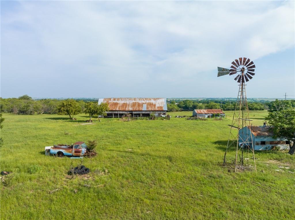 Welcome to country living! When you step outside and hear the grasshoppers and corn rustle in the wind you know you are home! This property has a never dry tank with turtles and fishing, and they are what memories are made of! This 159-acre ranch is beautiful with so much opportunity to make your own! The older ranch house is ready to be updated and remodeled, currently be sold as is. Gorgeous views of Texas country living! The property has a windmill, out buildings, and hay barn. Are you looking for a country quiet lifestyle? This is where you want to be! Raise cattle and chicken, harvest corn, what more can you ask for?!