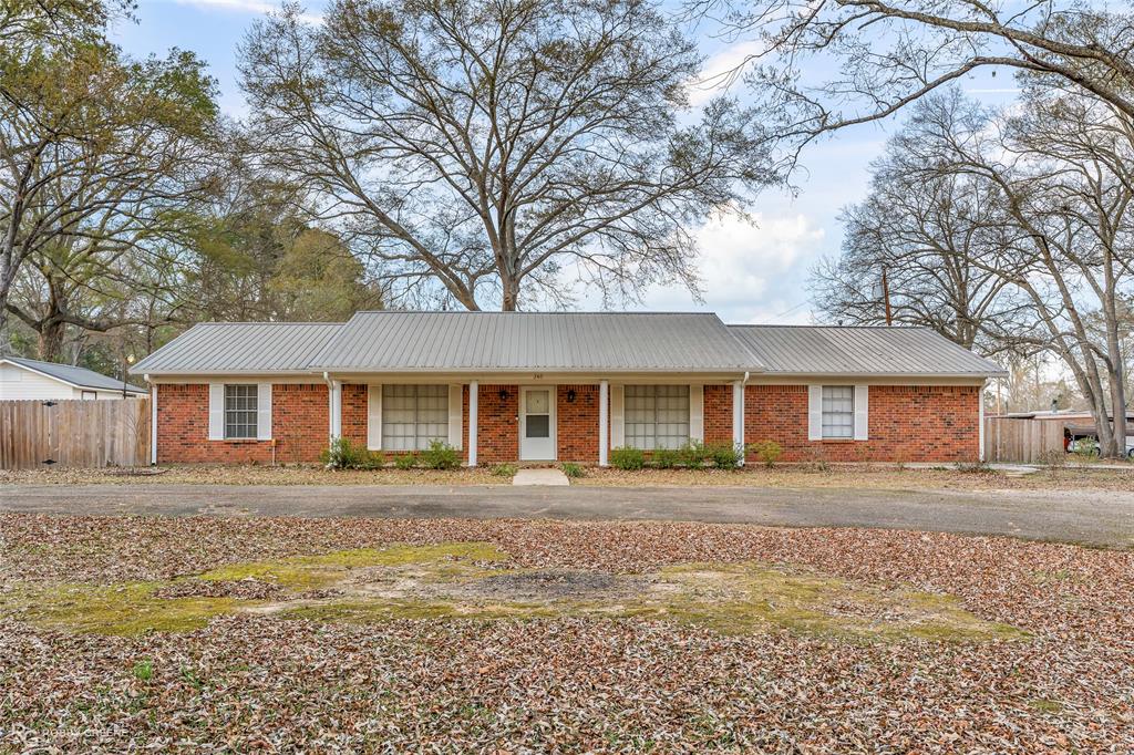 This 3 bedroom, 2 bath brick home sits on a beautiful large corner lot - nearly an acre - it is truly a MUST SEE. From the gorgeous wood flooring to the granite counter tops and into the yard, you will fall in love with this one. The living room boasts a traditional wood burning fireplace and built in shelves with plenty of natural lighting. The Primary bedroom hosts a bathroom with a walk-in closet and the hall bathroom is spacious and has lots of storage. Dual sinks and closets for shelving and hanging. Plenty of cabinets and storage in this home. Formal dining room is perfect for the family gatherings or it can be turned into a home office. The back yard and covered patio are perfect for relaxing or entertaining. Landscaped yard with a 16x20 storage building with electricity which has two separate sides. Be sure to take a look in there when you book your showing. Privacy fence around the entire back yard and a circle driveway in the front of the house and another driveway on the side of the house that goes into the 2 car garage. Utility room that leads outside off of the kitchen. Schedule your showing today! Come make this incredible house your new home.