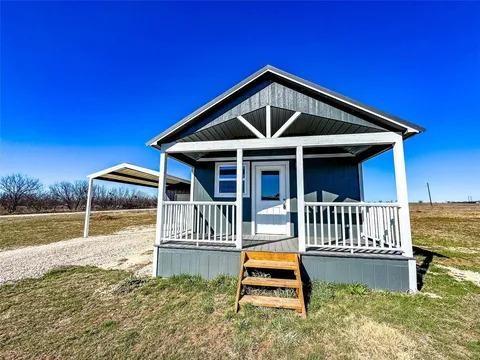 Escape to this stunning one bedroom lake cabin, built with all natural wood for a warm and inviting feel. Situated on land with breathtaking lake views, this home offers the perfect mix of comfort and convenience. Enjoy an open floor plan with appliances, heating, cooling, and a tankless water heater creating a modern yet rustic retreat. Relax on the spacious front porch or take advantage of the half acre lot, which provides ample space for outdoor enjoyment. The property also includes a carport with a storage shed for all your needs. This completely electric home is move in ready. Just around the corner from Lake Stamford! Perfect as a weekend getaway or full time residence. Don’t miss this rare opportunity to own a beautiful lake retreat! Schedule your showing today!