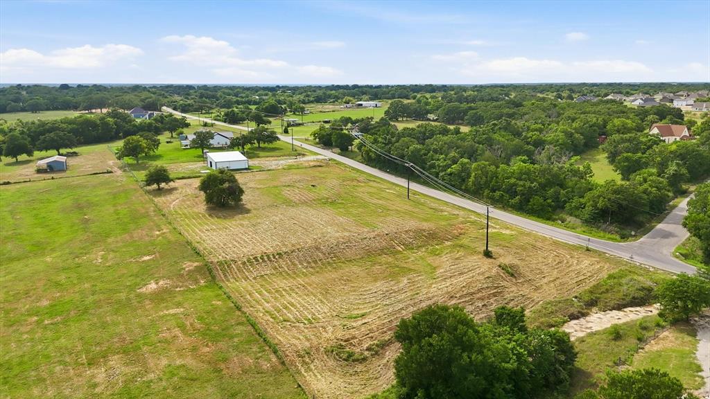 GIVE ME A HOME WHERE THE BUFFALO ROAM! Escape the hustle and embrace the beauty of country living with this unique 3-acre property offering breathtaking views of the Old West, where buffalo graze nearby pastures and wildlife including deer and wild turkey frequently wander the landscape. Whether you're dreaming of building your custom home, creating a weekend retreat, or establishing a home base for your RV adventures, this versatile property offers endless possibilities! Comprised of three separate 1-acre lots being sold together, the property provides flexibility to keep it all for added privacy or potentially divide and utilize the lots to fit your future plans. Built in 2023, the impressive 40x40 barn is ready to serve a variety of needs. Featuring large bay doors on both ends for convenient pull-through access & cross ventilation, it's ideal for RV storage with full hook ups and 30 am service. The entire structure is foam insulated so it stays cool in the summer and warm in the winter plus already outfitted with water, electric & septic! Attached is 560 square feet of air-conditioned office-living space complete with electricity & washer-dryer hookups, making extended RV living comfortable and convenient while providing valuable climate-controlled storage & workspace. An additional 18x14 carport offers even more covered parking for vehicles, trailers, equipment, or recreational toys. The pasture is already established with quality coastal grass and native bluestem, creating excellent grazing opportunities for horses or livestock. A seasonal creek meanders along the eastern boundary, while several terraced and graded building sites provide excellent locations to bring your dream home to life. With wide-open skies, abundant wildlife, improved infrastructure already in place, and room to create the lifestyle you've always imagined, this property is a rare opportunity to own a slice of Texas countryside with unlimited potential! Call today to make it yours!